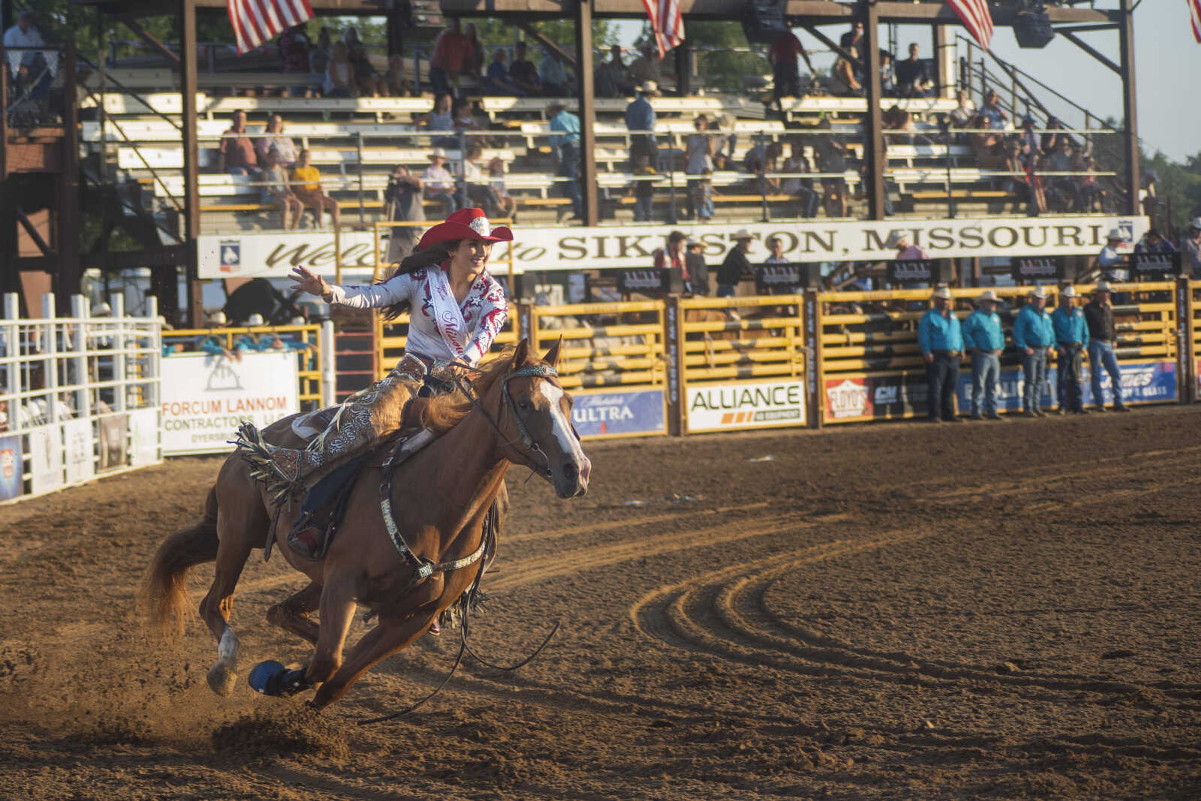 A rider waves to the crowd during the opening ceremonies of the Sikeston Jaycee Bootheel Rodeo on Wednesday, Aug. 11, 2021, in Sikeston, Missouri.