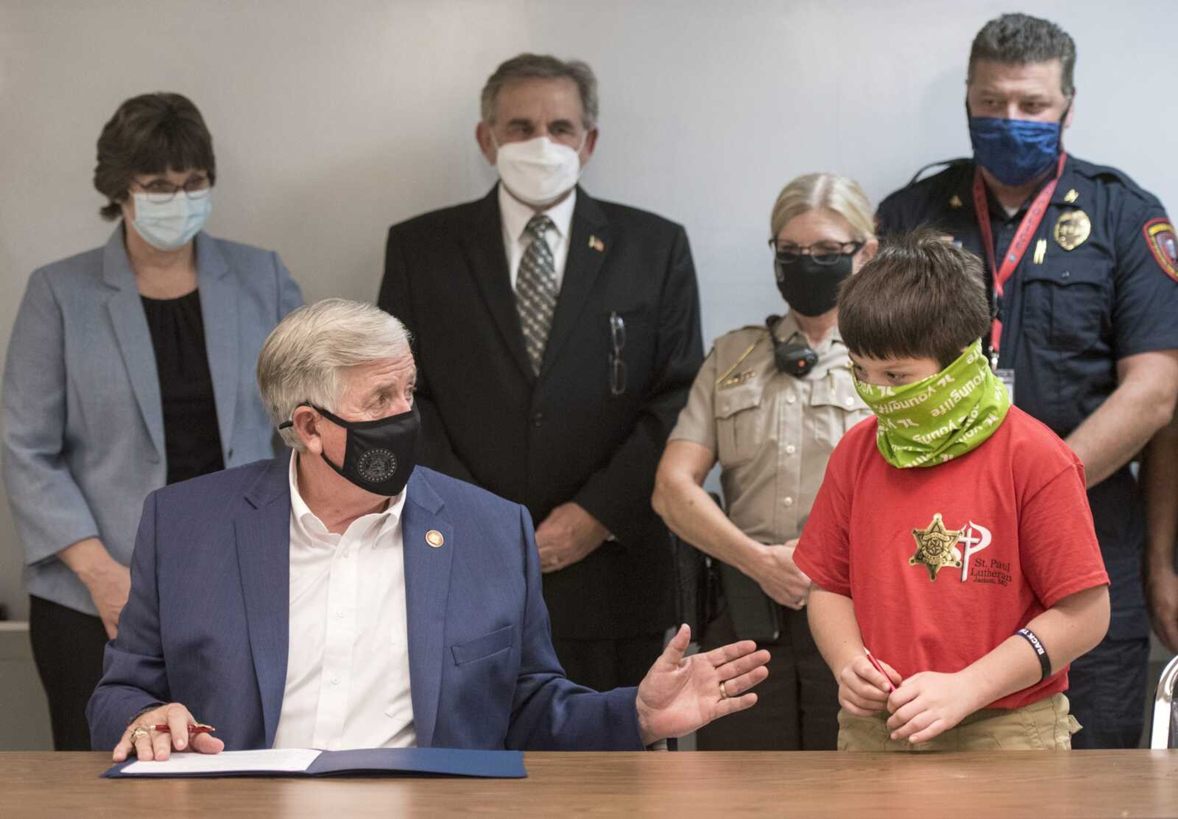 Gov. Mike Parson speaks to 11-year-old Theodore Tracy of Cape Girardeau during a ceremonial signing of HB 66 on Tuesday at the Cape Girardeau County Sheriff's Office in Jackson.