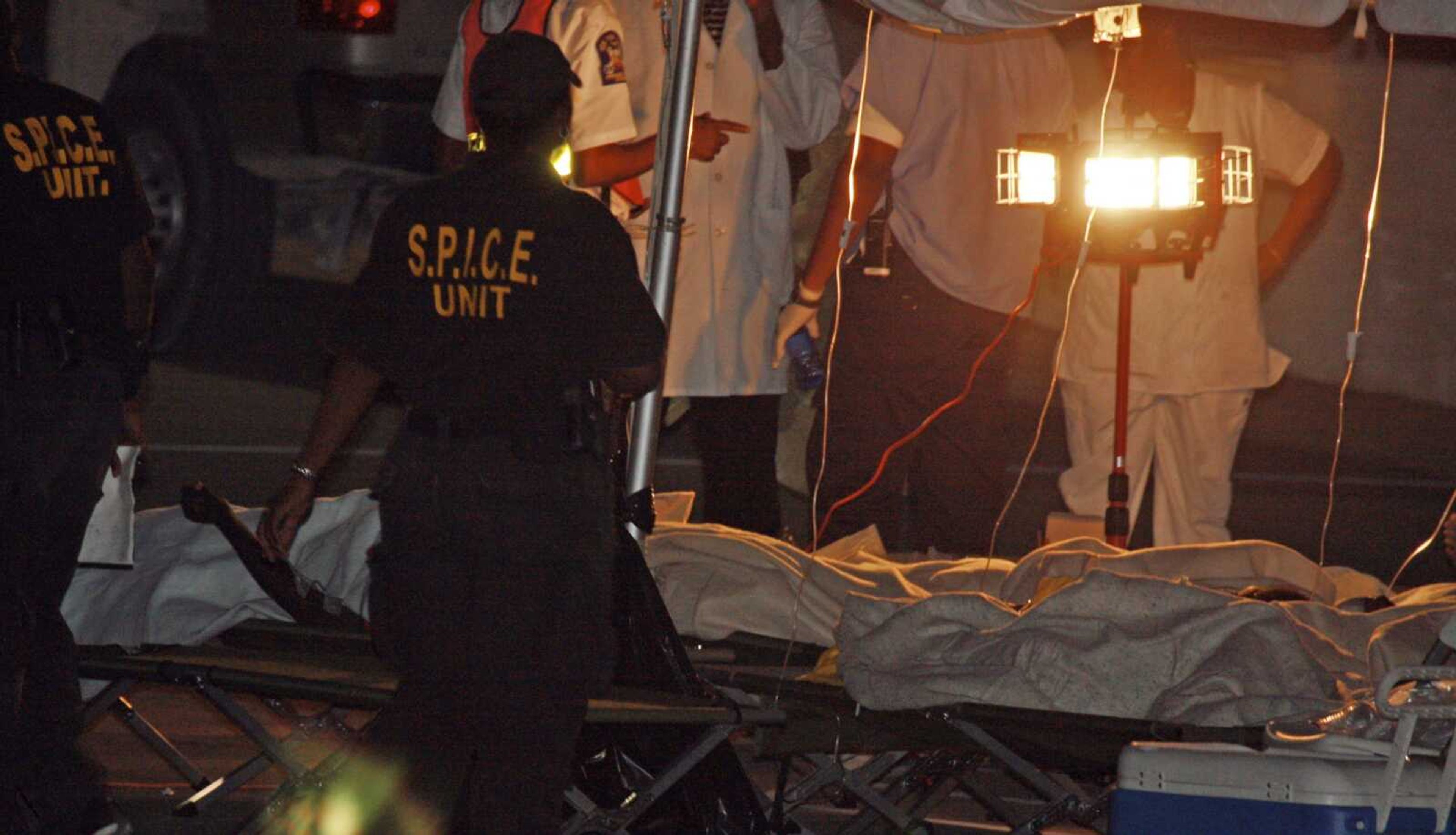 Special Police Immigration Customs Enforcement officers and medical personnel attend to survivors of a capsized boat Tuesday in Providenciales, Turks and Caicos. Rescuers searched for nearly 70 Haitians after an overloaded sailboat capsized. (Robert K. Houseman ~ Associated Press)