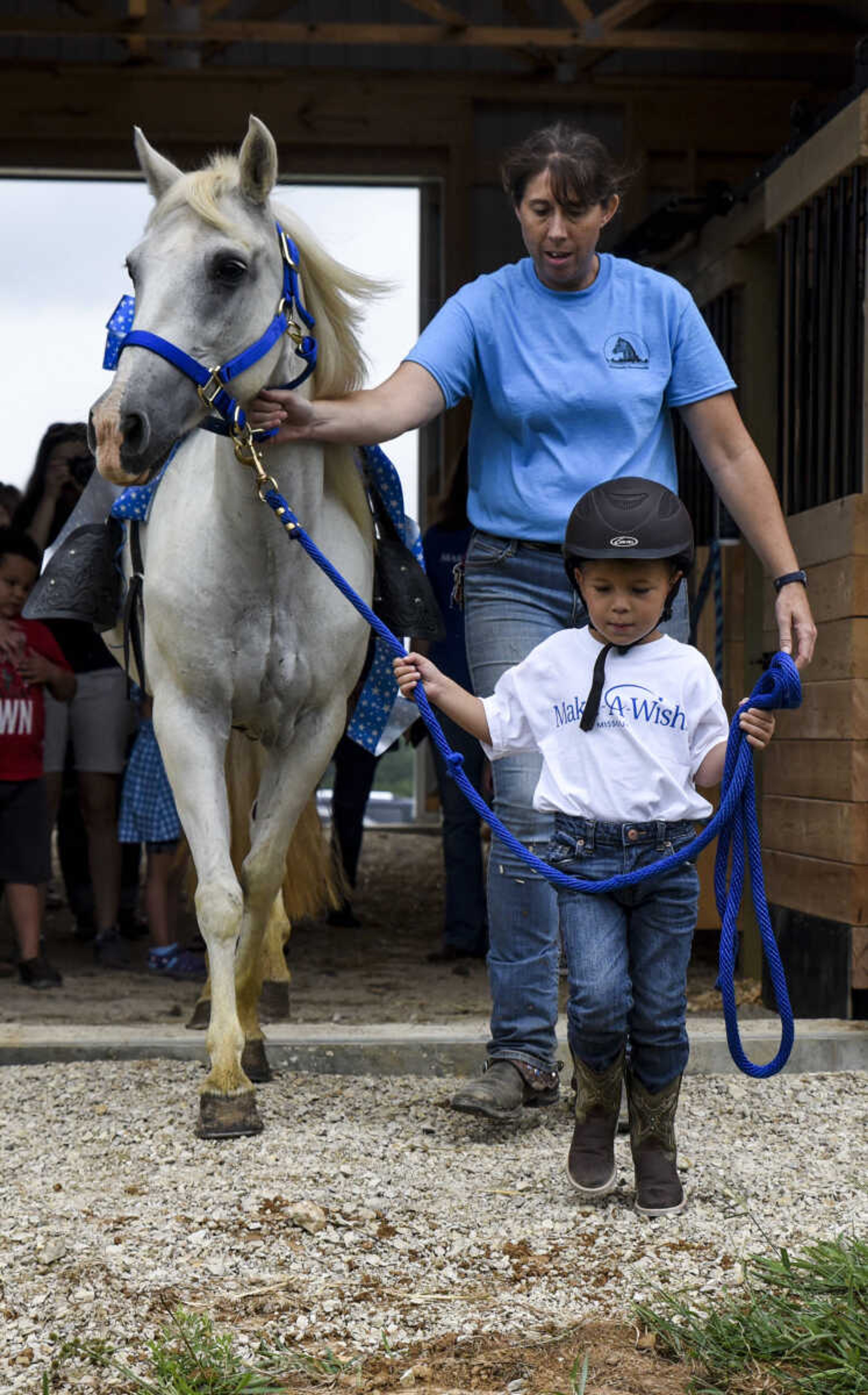 Nate Prichard, 5, leads his new horse Silver out of the barn with the guidance of Varina Luttrull, program director for Mississippi Valley Therapeutic Horsemanship, Monday, July 30, 2018 in&nbsp;Burfordville.