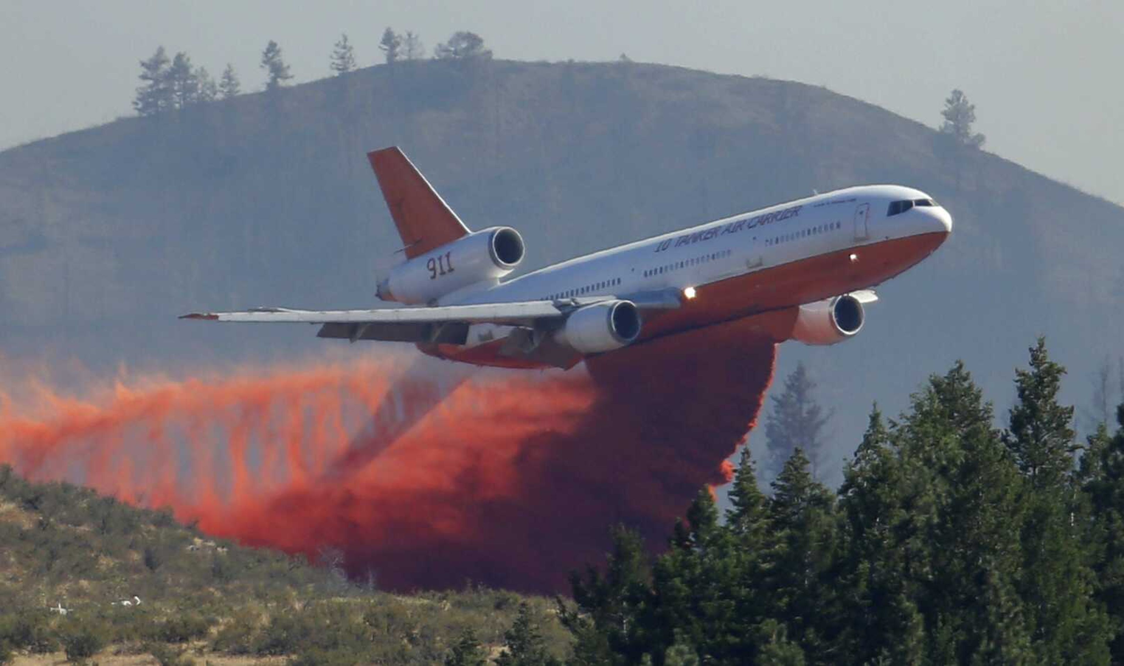 A tanker airplane drops fire retardant on a wildfire Aug. 21 north of Twisp, Washington. The U.S. Department of the Interior said it's working with drone makers and mapping companies to create a system allowing smartphones to update no-fly zones at wildfires.