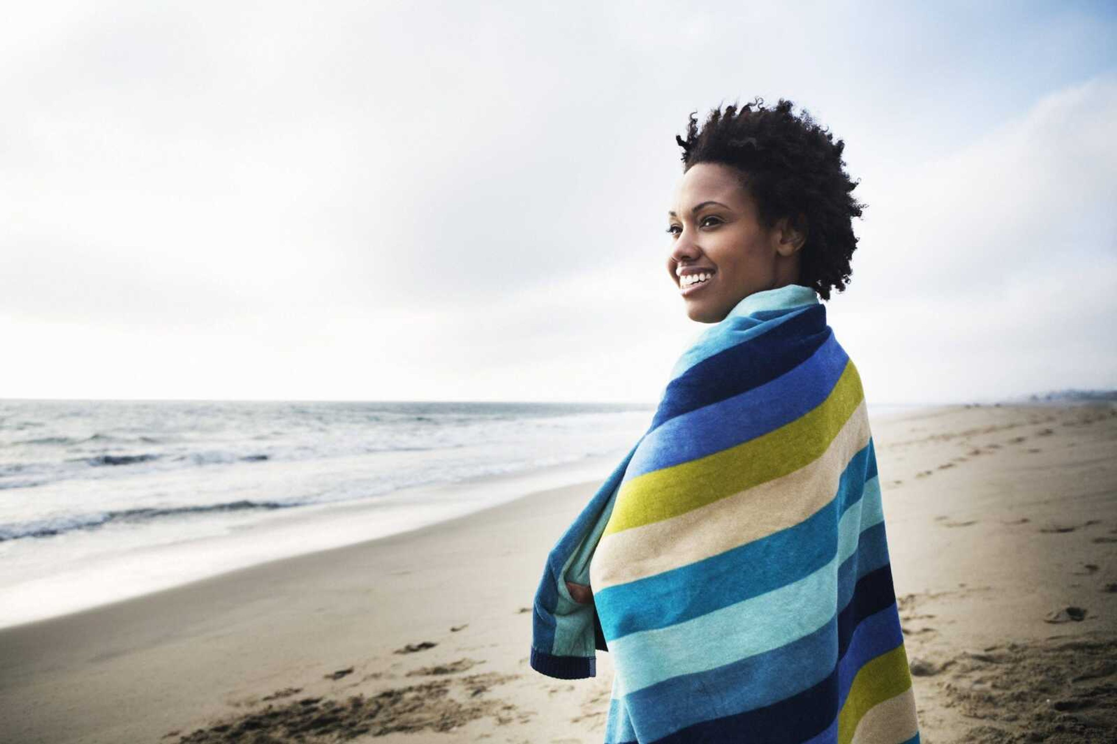 Mid-adult woman wrapped in towel on beach