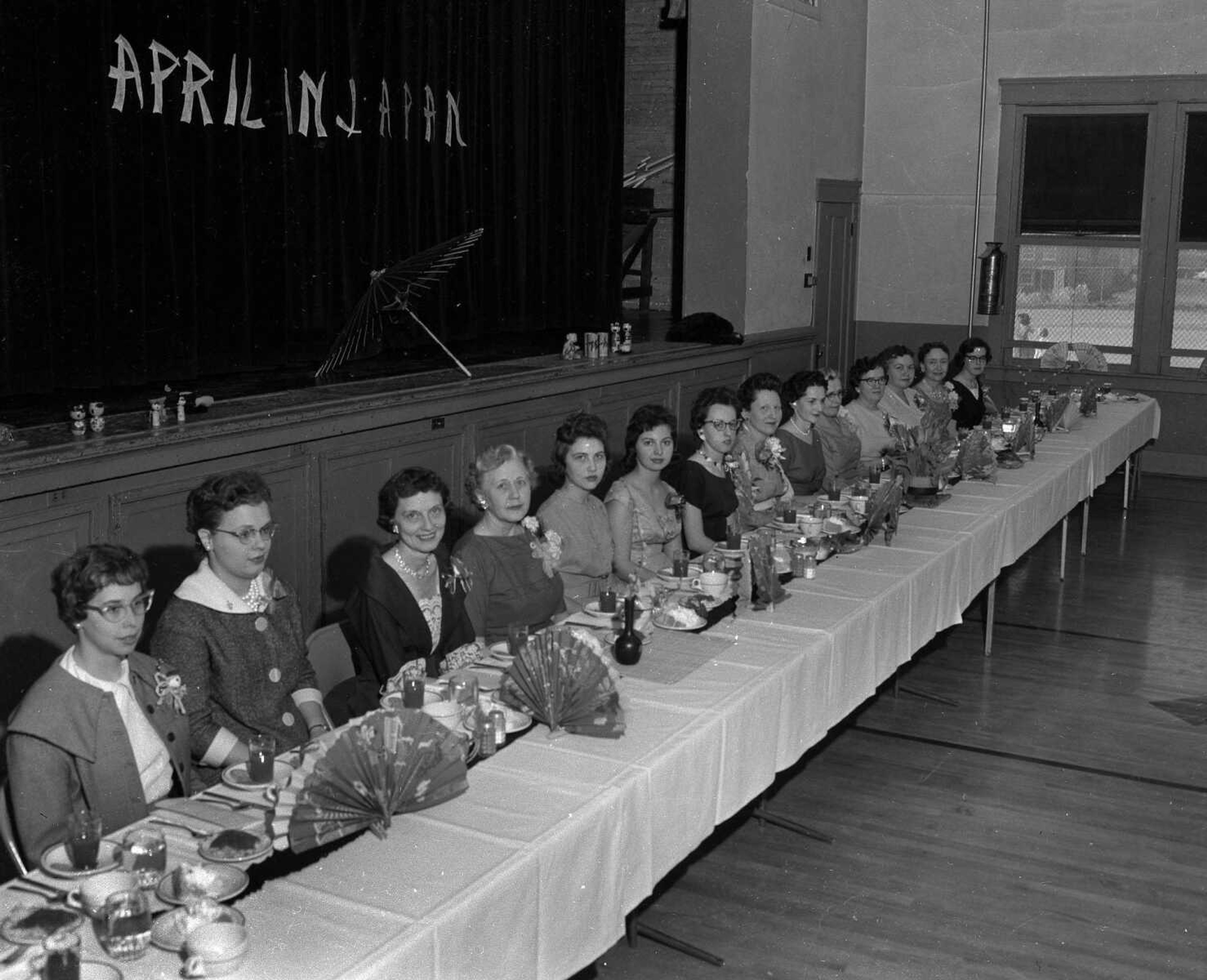 The curtain hanging behind these ladies sports the words: "April in Japan." Do you recognize this photo?