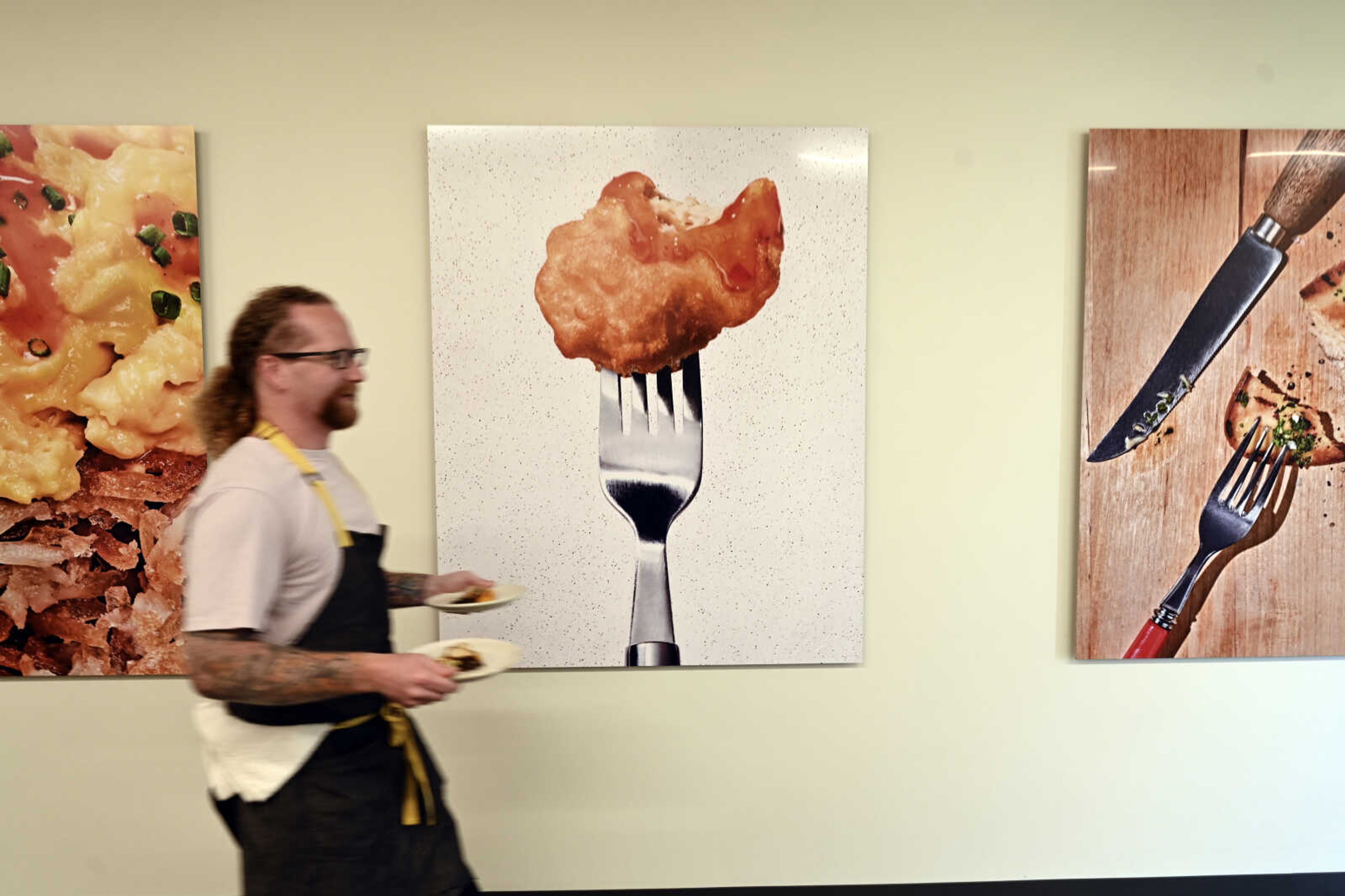 Chef Zach Tyndall carries plates of cultivated chicken at Good Meat's headquarters Sept. 28 in Alameda, California.