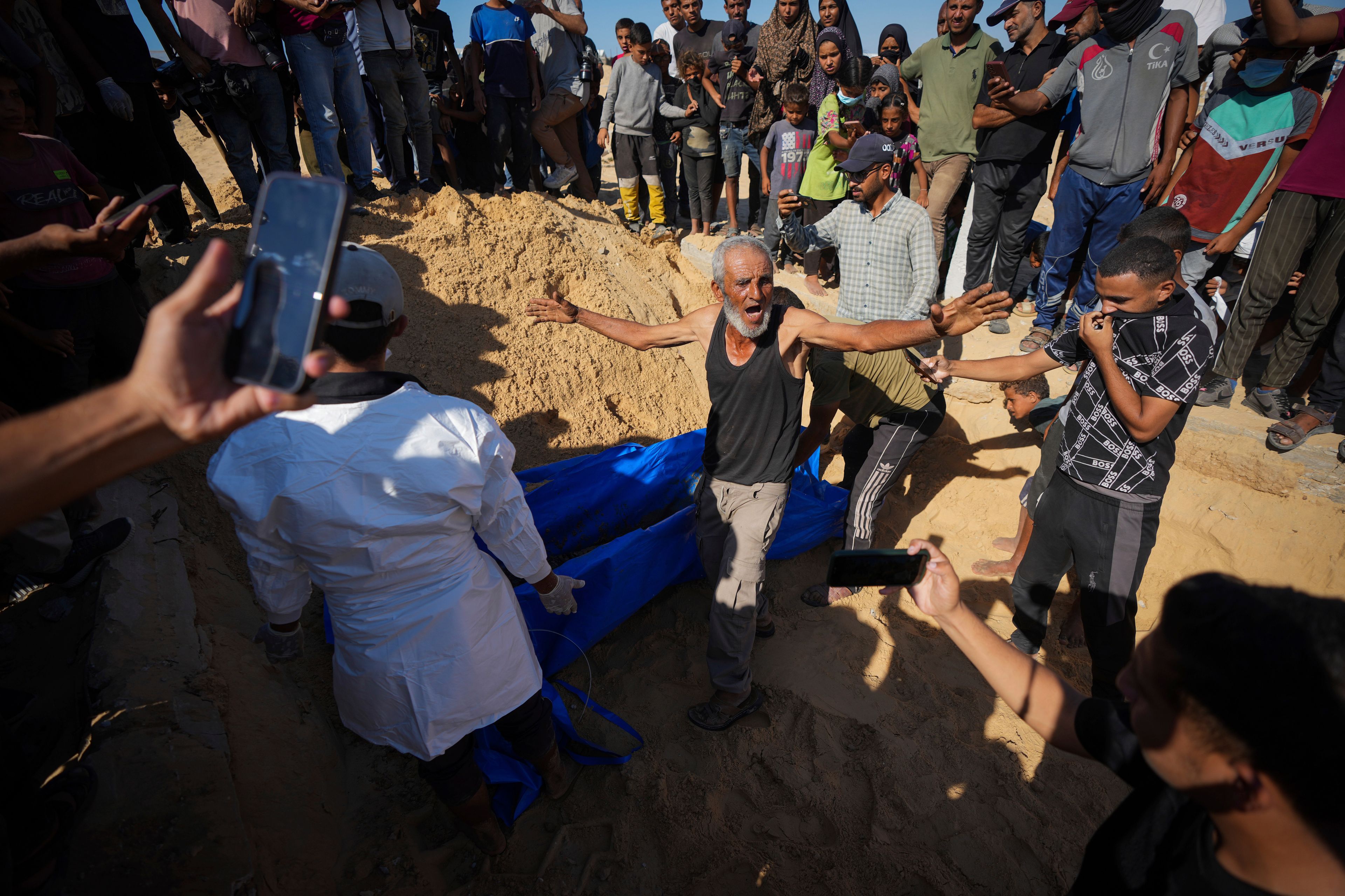 People bury the bodies of Palestinians taken by the Israeli military during operations in Gaza and returned this week, in Khan Younis, Gaza Strip, Thursday, Sept. 26, 2024. (AP Photo/Abdel Kareem Hana)