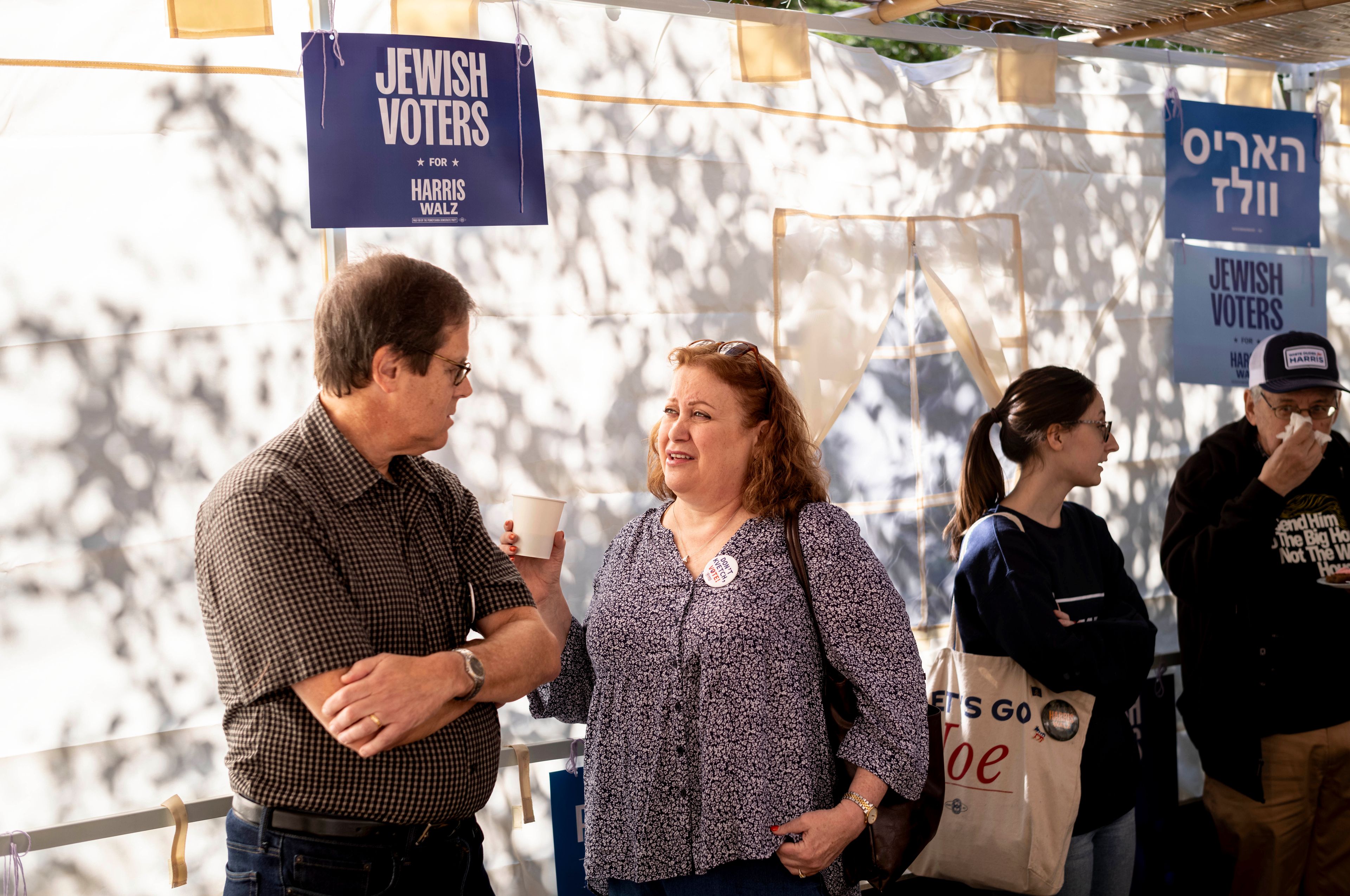 Mark and Suzan Lopatin gather with other supportes of Democratic presidential nominee Vice President Kamala Harris in a Sukkot before going door to door to canvass Jewish voters Sunday, Oct. 20, 2024. (AP Photo/Laurence Kesterson)