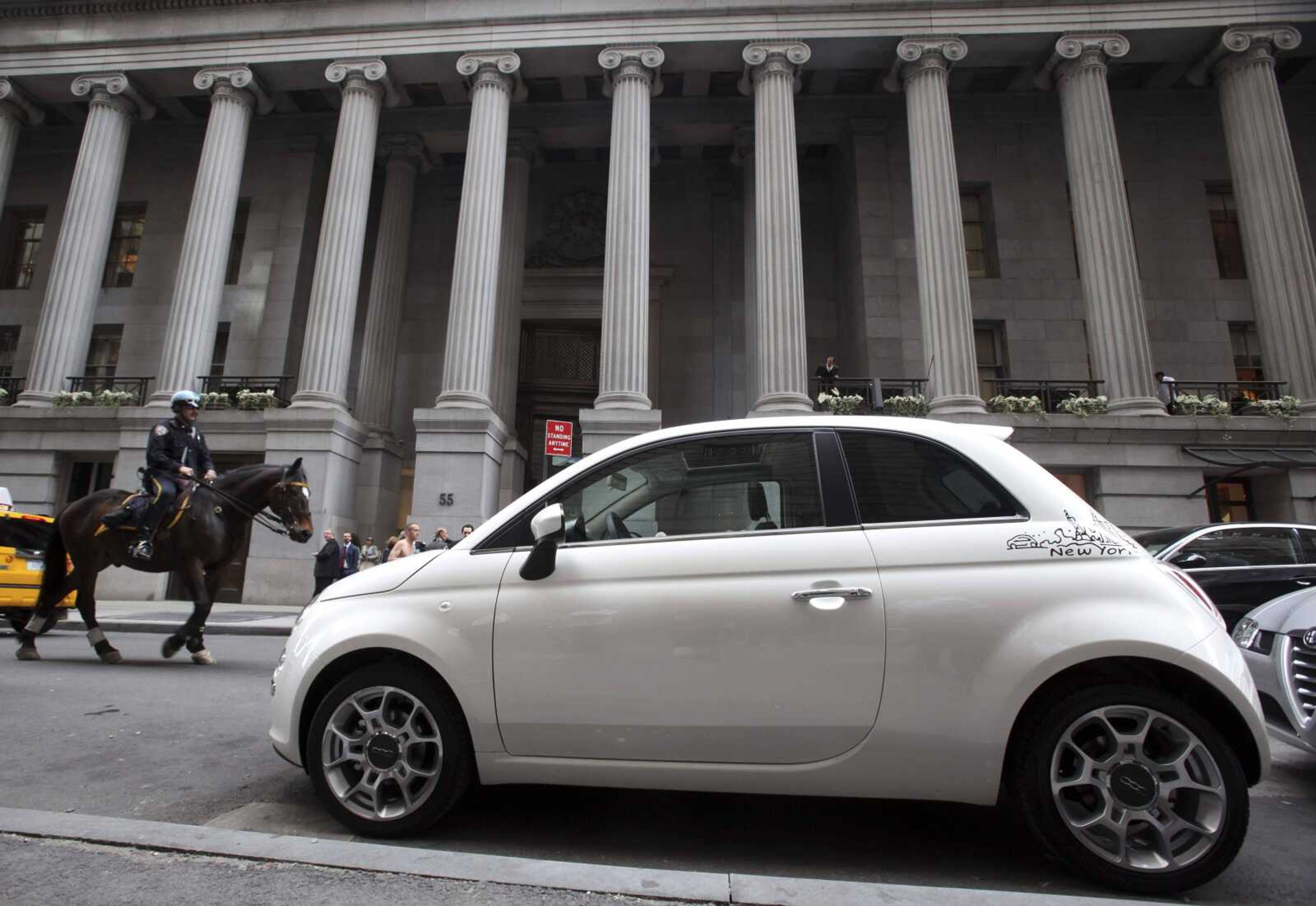 A Fiat 500 is seen June 1 parked outside a promotional event on Wall Street in New York. The new Chrysler began operations Wednesday after the transfer of most of old Chrysler's assets to Fiat. (Mary Altaffer ~ Associated Press)