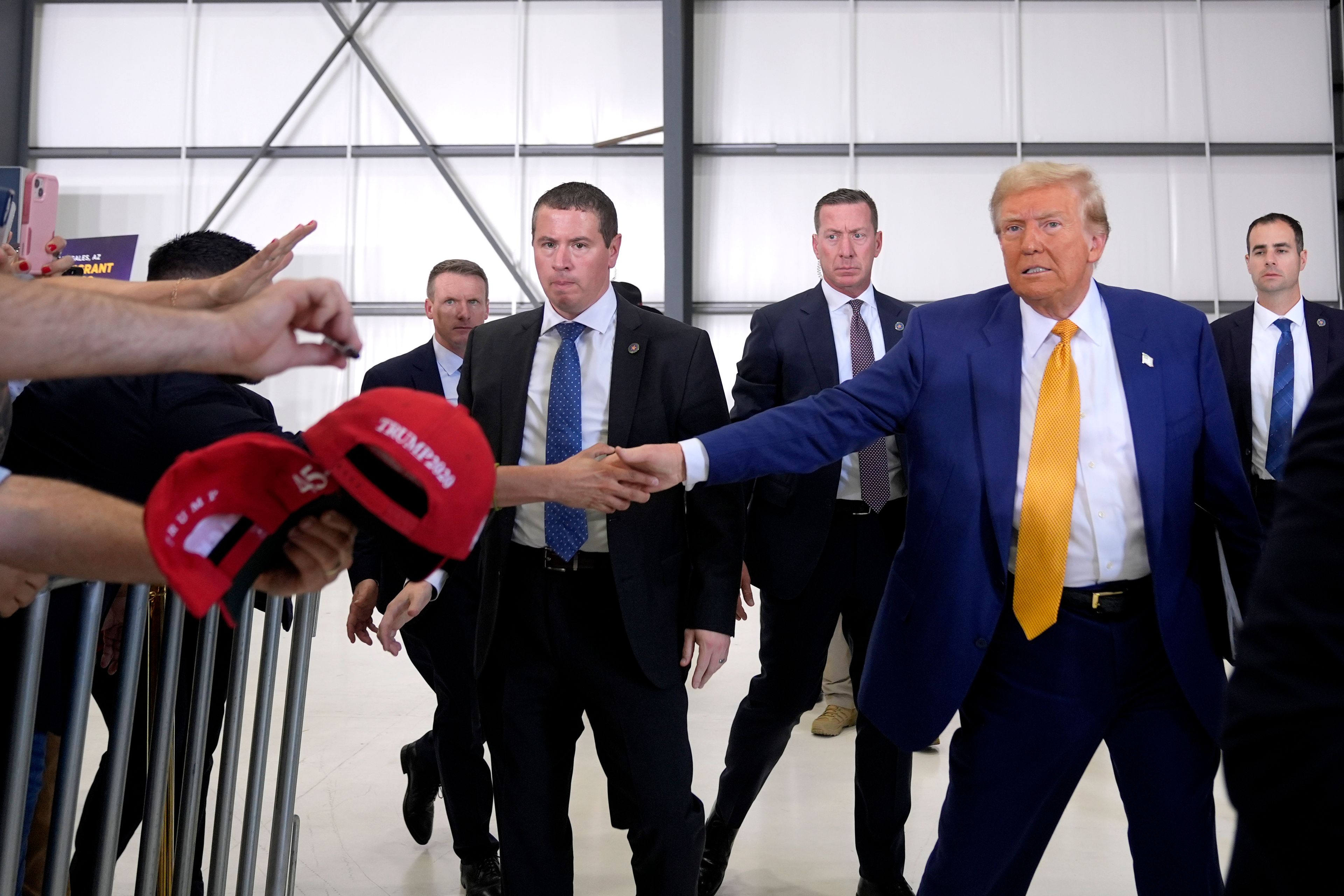 Republican presidential nominee former President Donald Trump shakes hands with an attendee as he departs a news conference at Austin-Bergstrom International Airport, Friday, Oct. 25, 2024, in Austin, Texas. (AP Photo/Alex Brandon)