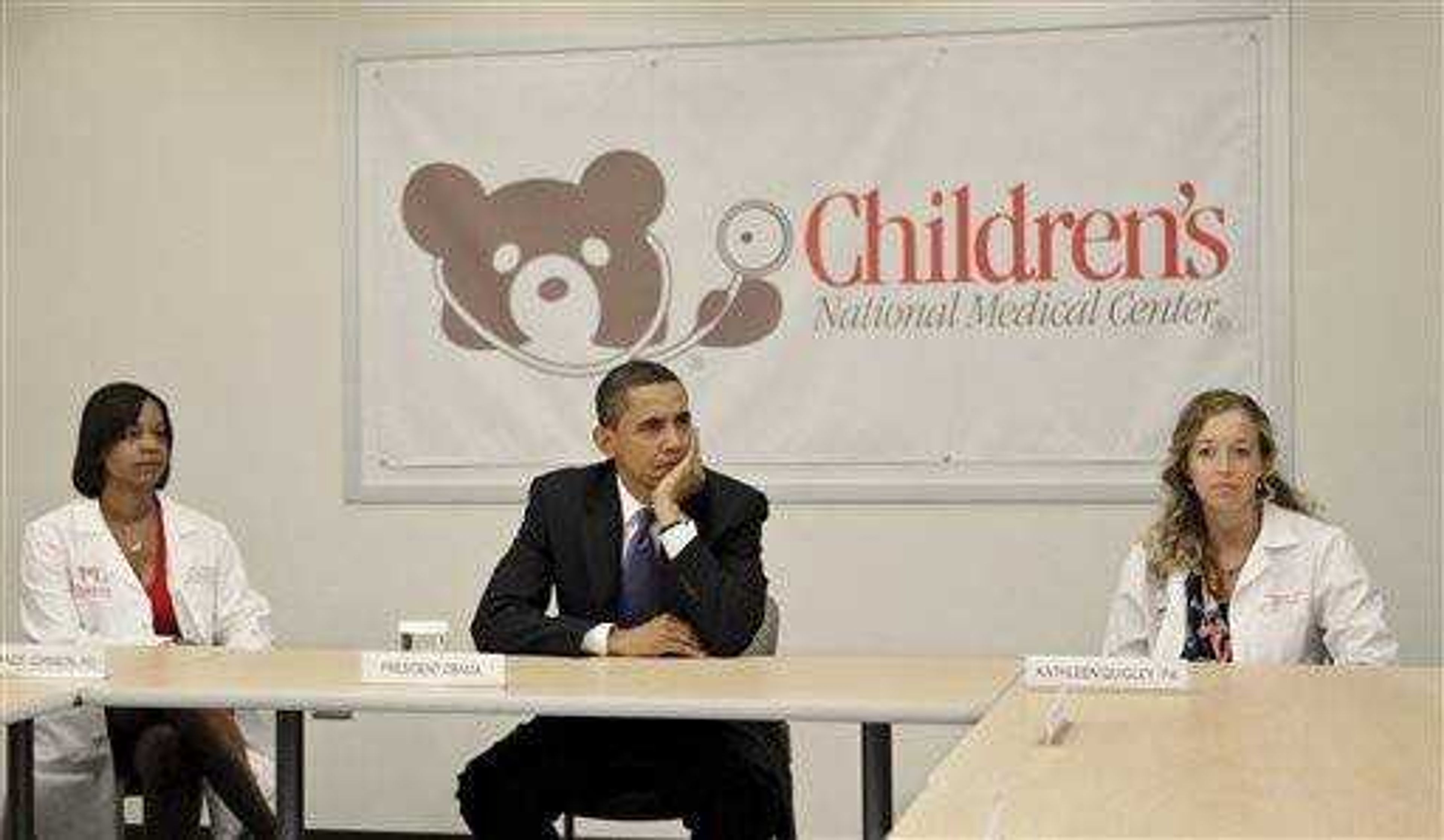 President Barack Obama attends a roundtable discussion with health care providers during a visit to Children's National Medical Center in Washington July 20. He is joined at left by Yewande J. Johnson, MD, a pediatric anesthesiologist specializing in pain medicine, and at right by Kathleen Quigley, a physician assistant in the Division of Neurosurgery at Children's National Medical Center. (AP Photo/J. Scott Applewhite)