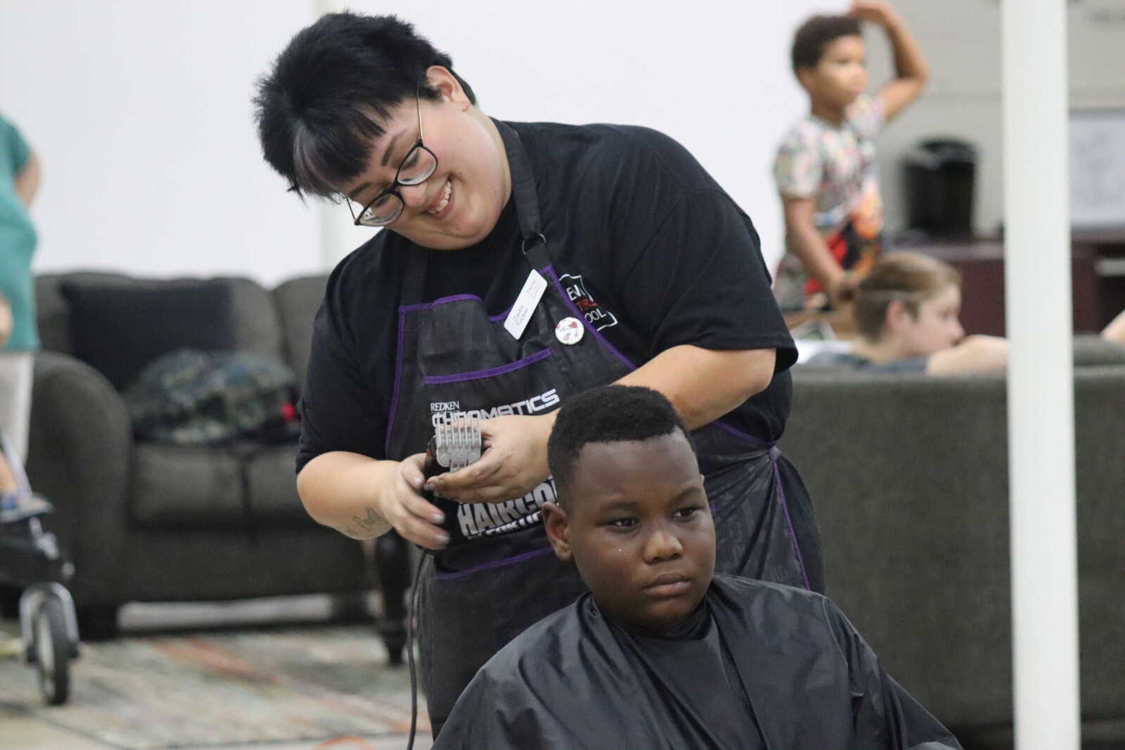 A child gets his haircut in the One City building at the Back to School Bash on Saturday.