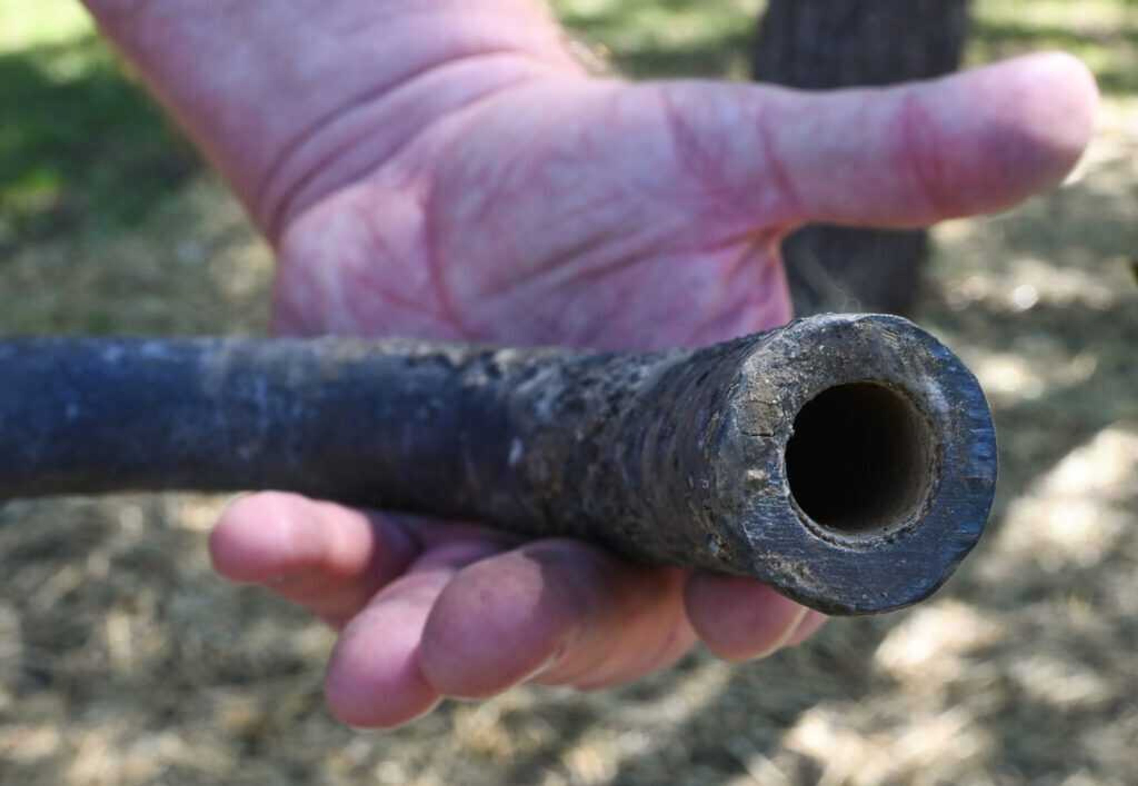 A piece of lead pipe removed from Jerry Land's yard in Olathe, Kansas, shows a layer of lining inside the pipe indicating the city's water supply provided a thin film that prevented the pipe from leeching lead into the home's water. President Joe Biden's administration is prioritizing lead pipe removal more than 30 years after new ones were banned.