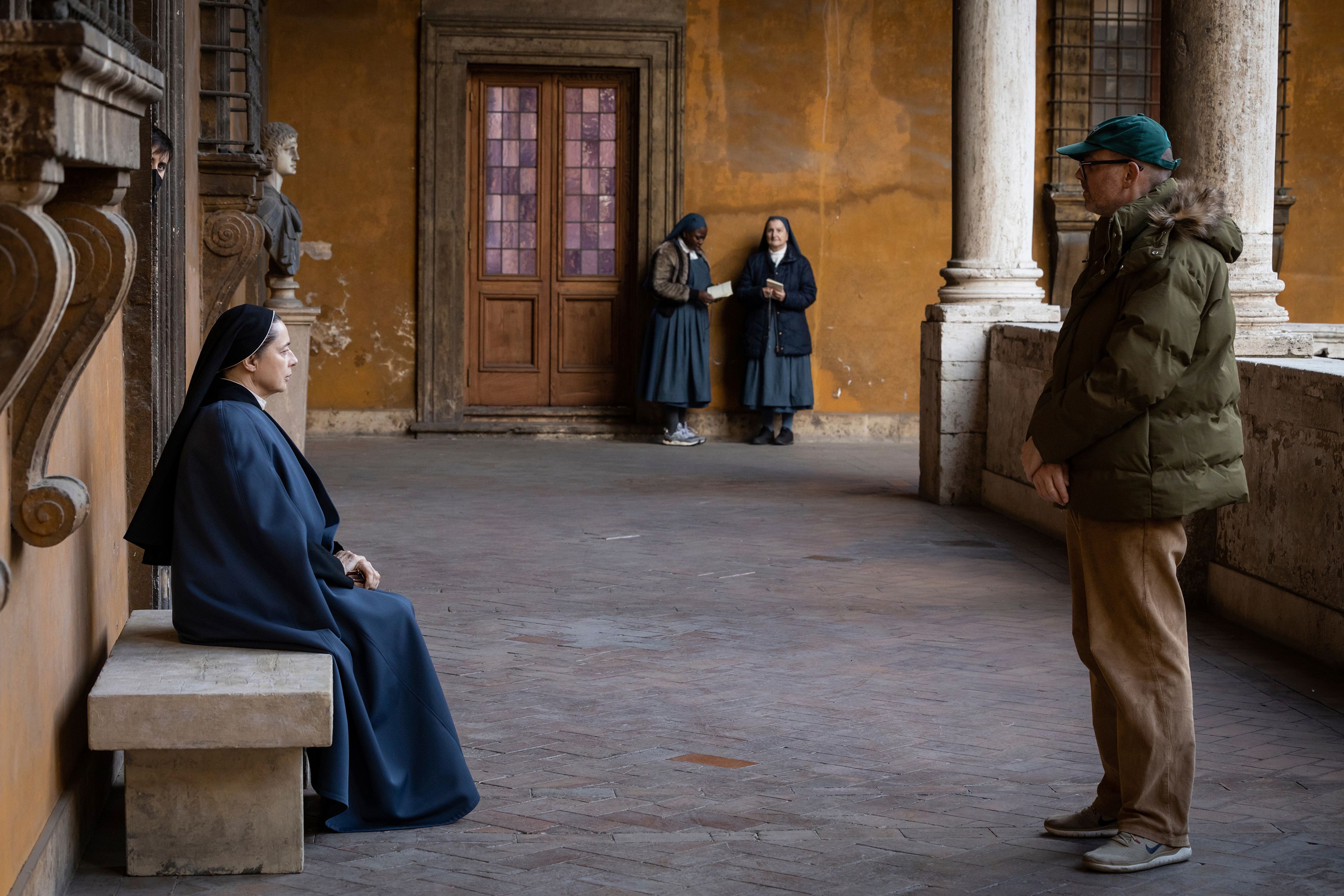 This image released by Focus features shows actor Isabella Rossellini, left, and director Edward Berger on the set of "Conclave." (Philippe Antonello/Focus Features via AP)