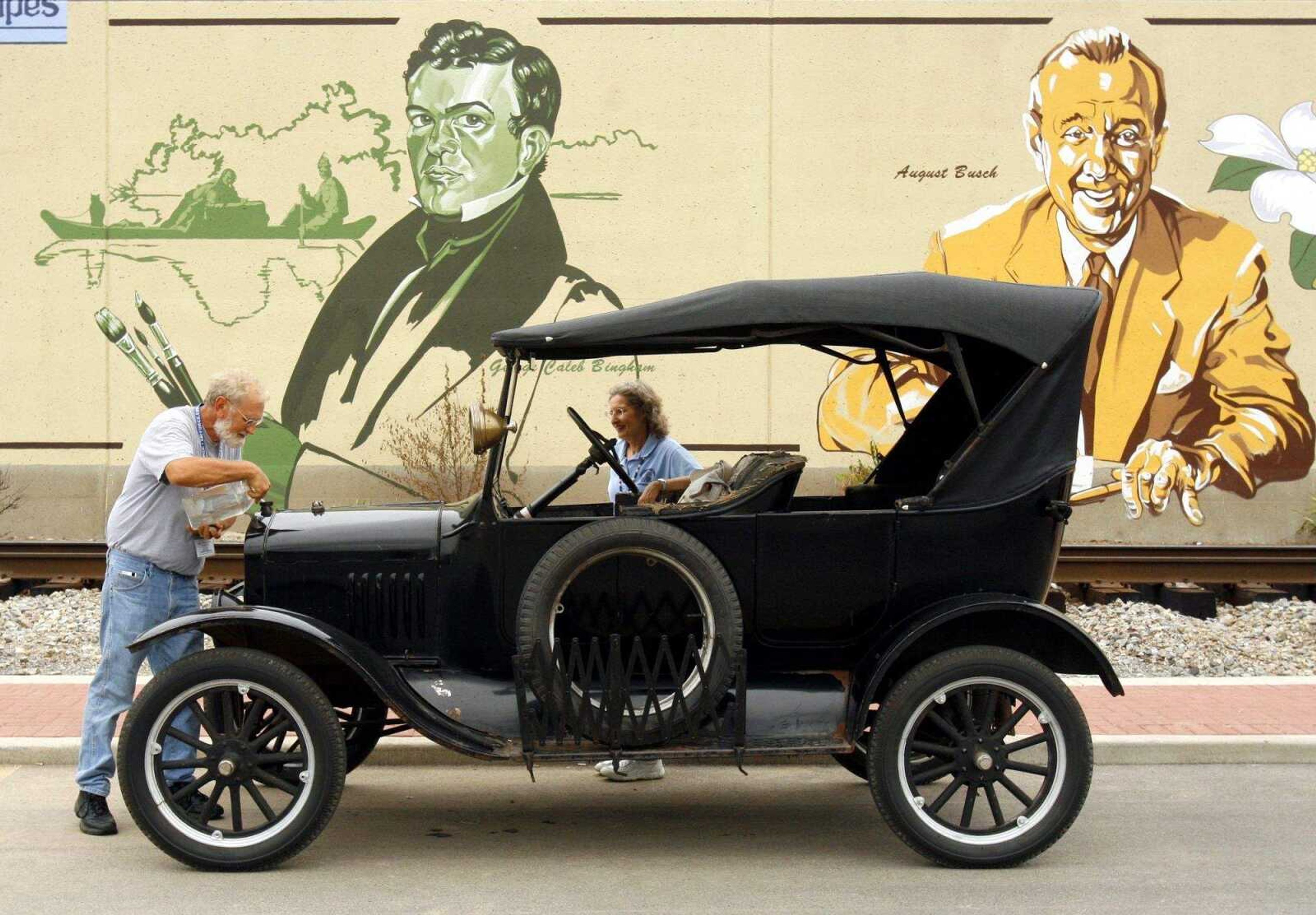 ELIZABETH DODD ~ edodd@semissourian.com
Roger Wermeskerch, of Lincoln Neb., left, put radiator fluid in his 1924 Model T Ford while touring downtown Cape Girardeau Wednesday with his wife, Bethine.