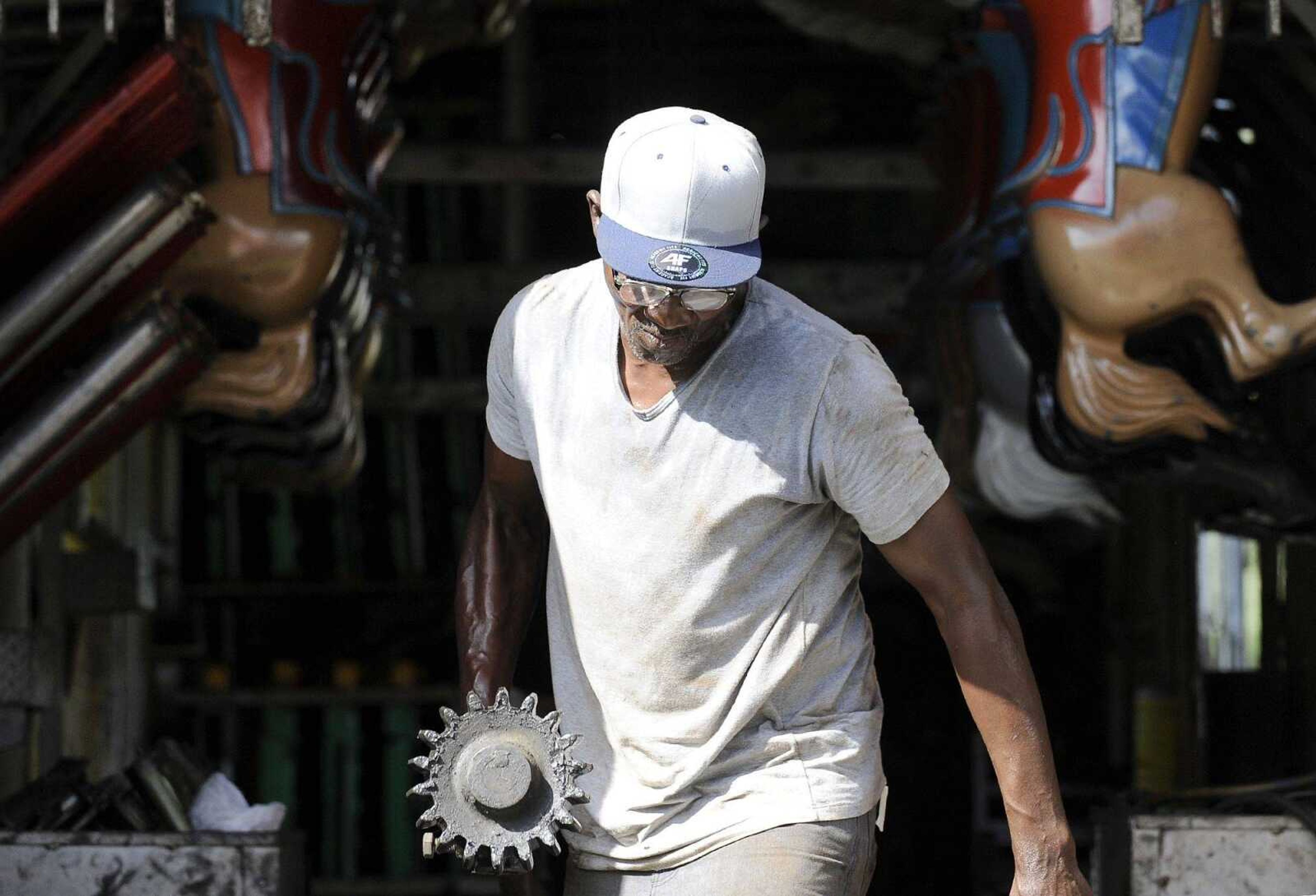 Maurice Braxton works on assembling the carousel Tuesday in the midway for the SEMO District Fair at Arena Park.