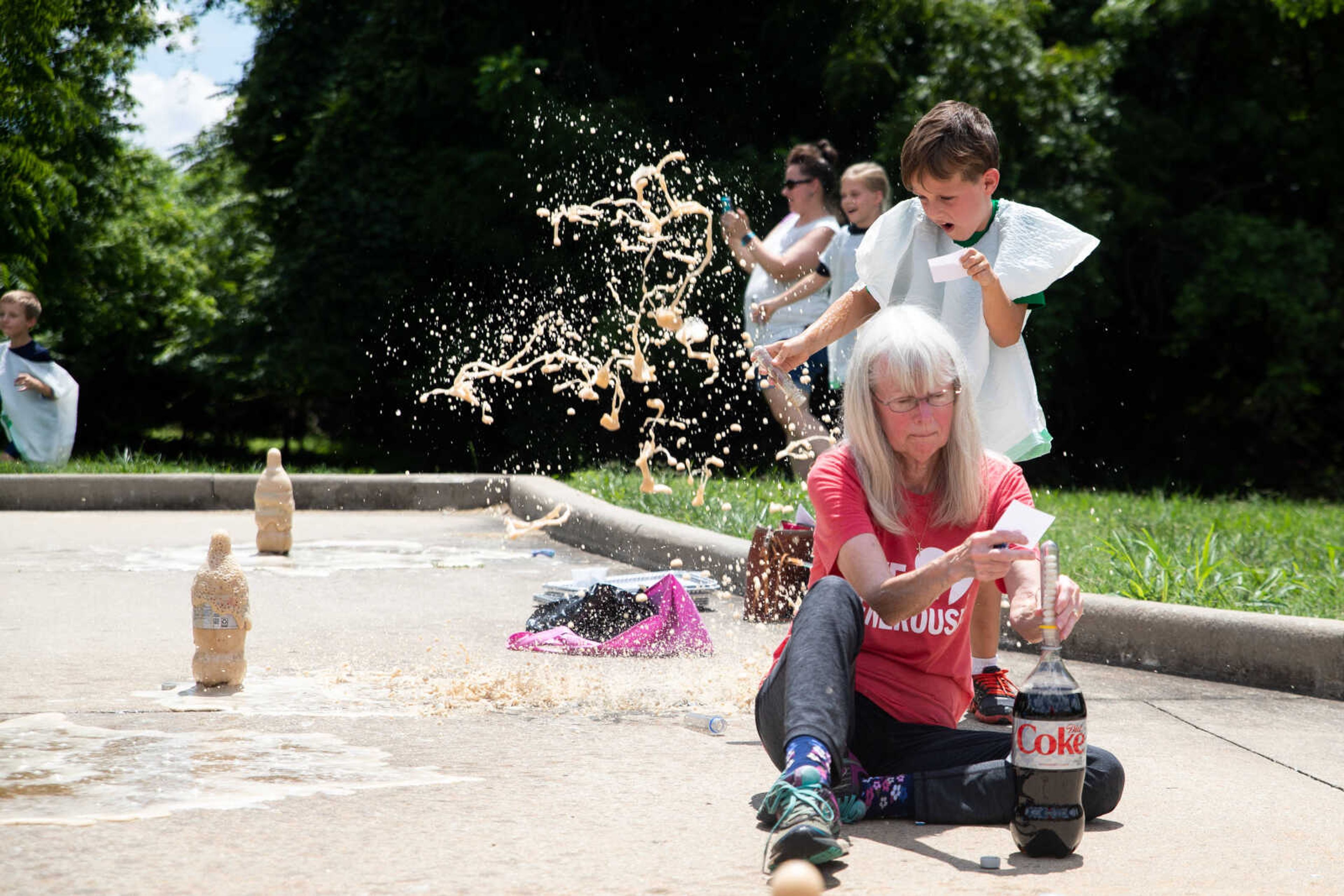 Matthew Young and Lynne Eisman drop Menthos into Coke bottles, creating an explosion.