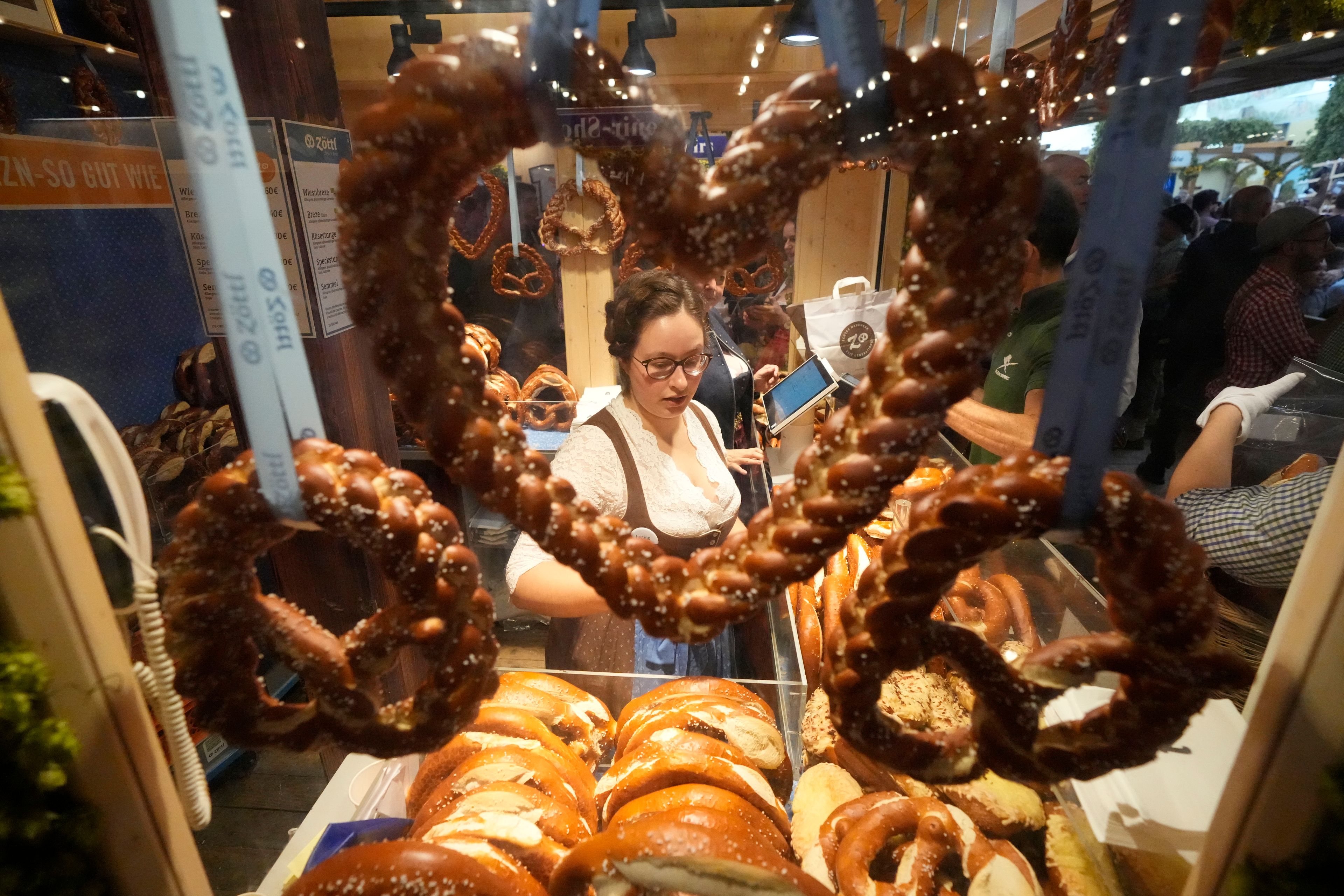 A woman sells Pretzels at the Hofbraeuhaus beer tent on day one of the 189th 'Oktoberfest' beer festival in Munich, Germany, Saturday, Sept. 21, 2024. (AP Photo/Matthias Schrader)