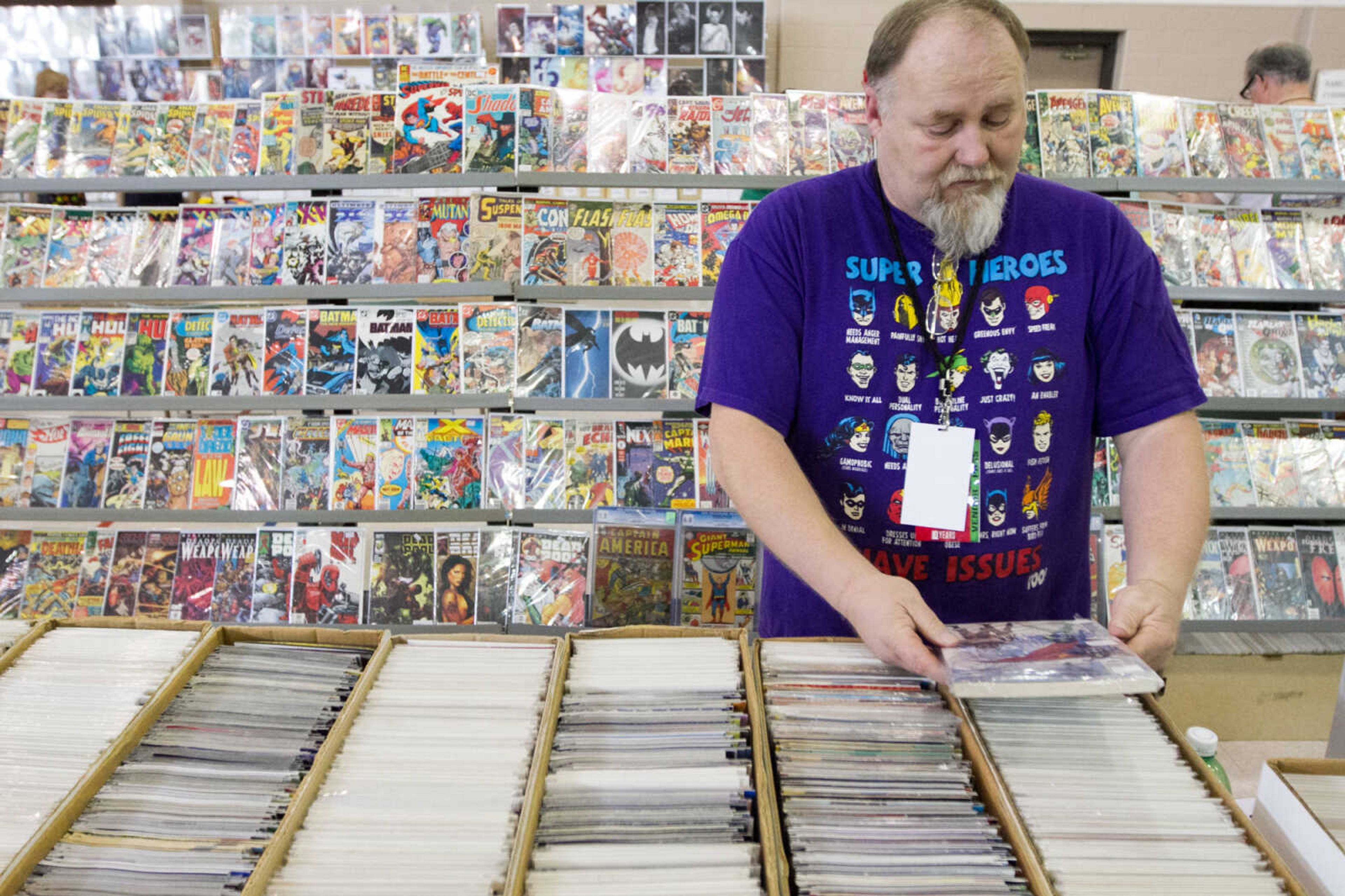 GLENN LANDBERG ~ glandberg@semissourian.com

Alvin Minnick checks the price on one of his comic books for sale at his booth during the Cape Comic Con Friday, April 17, 2015 at the Osage Centre.