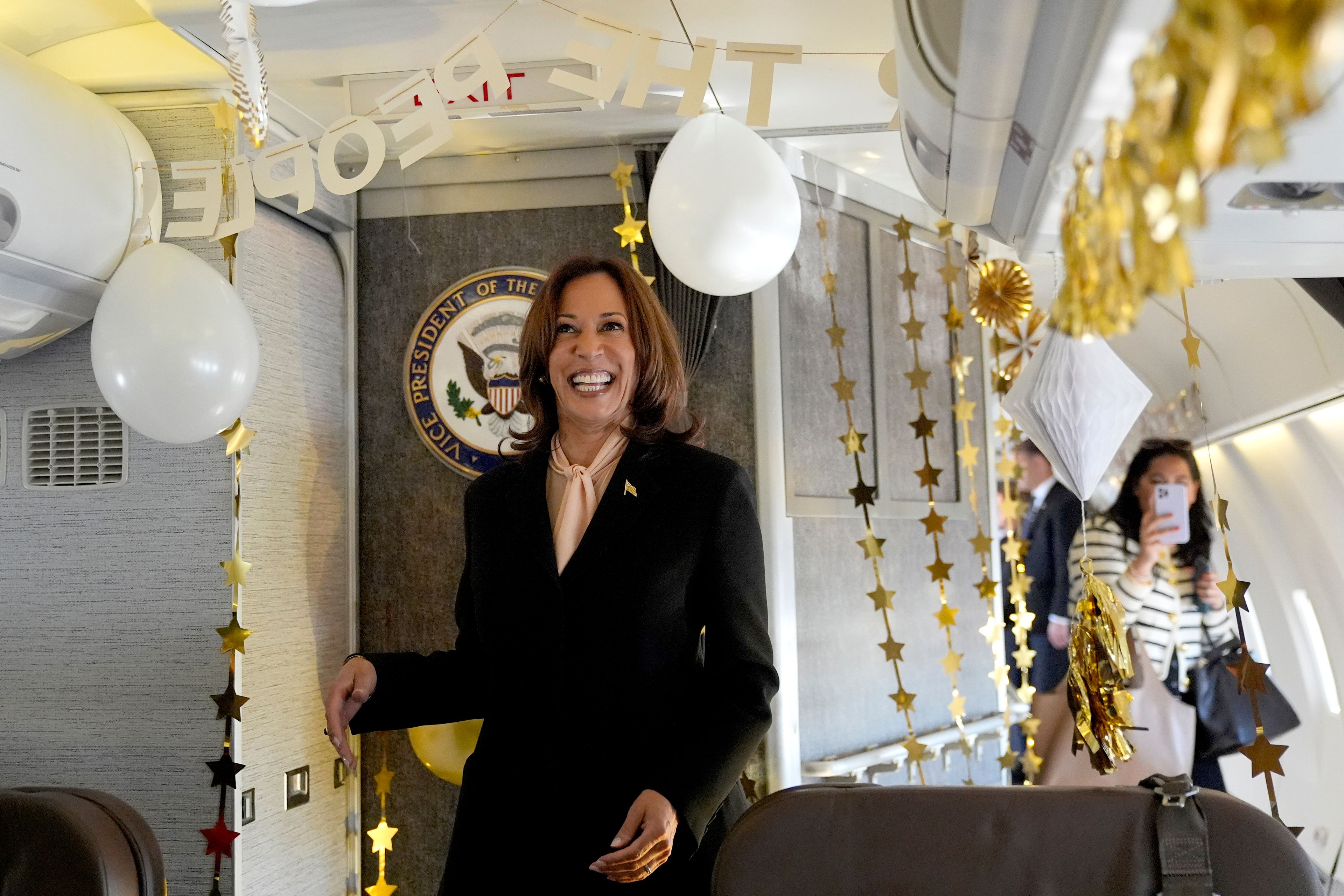 Democratic presidential nominee Vice President Kamala Harris is surprised by campaign staff with birthday decorations on Air Force Two before departing Hartsfield Jackson International Airport in Atlanta, Sunday, Oct. 20, 2024, en route to Philadelphia. (AP Photo/Jacquelyn, Martin, Pool)