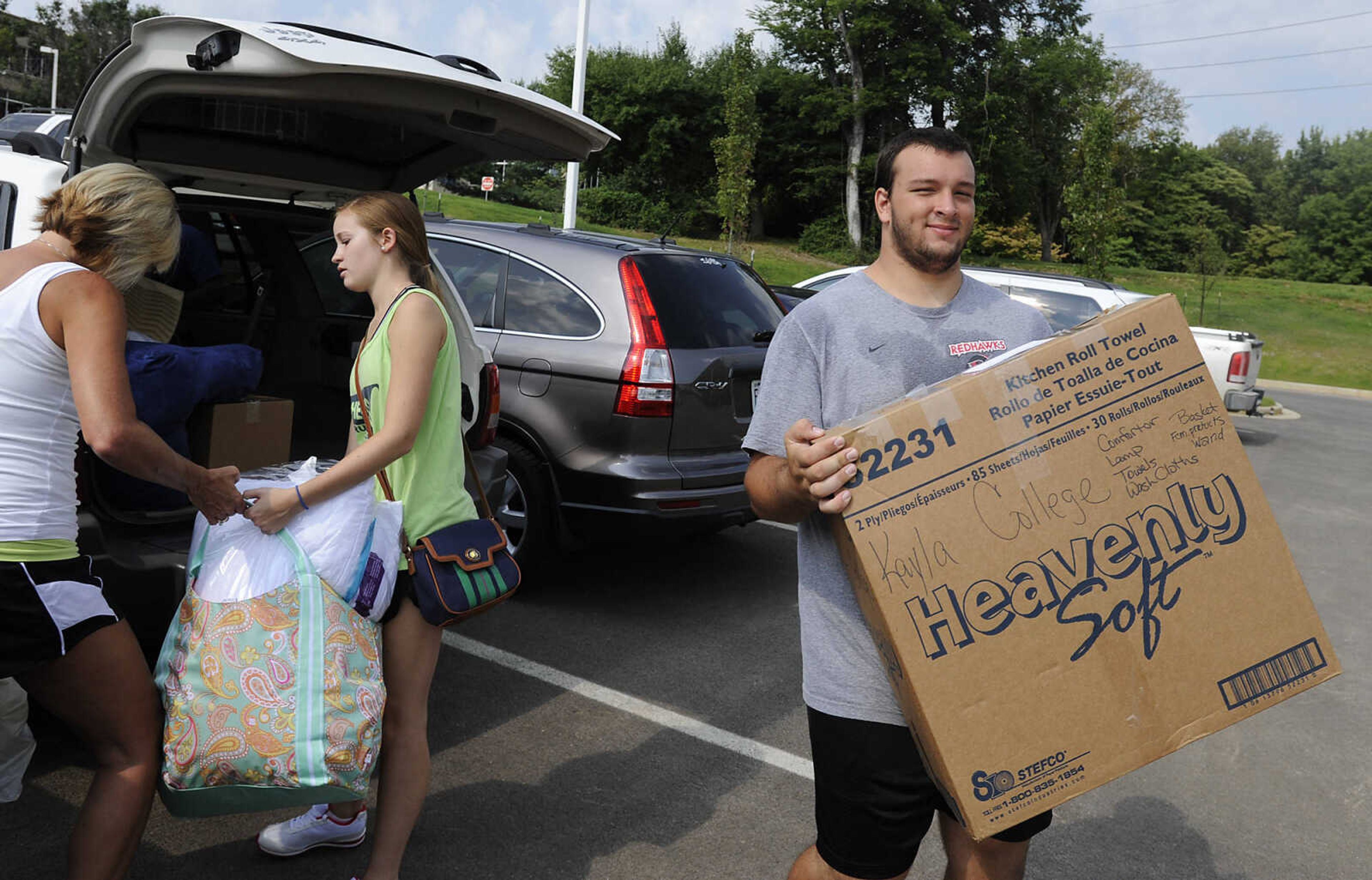 Southeast Missouri State University football player Billy Dasher, right, helps Kayla Vessel and Becky Bowman move Kayla's belongings into her dorm room in New Hall during move in day Thursday, Aug. 22, at Southeast Missouri State University.