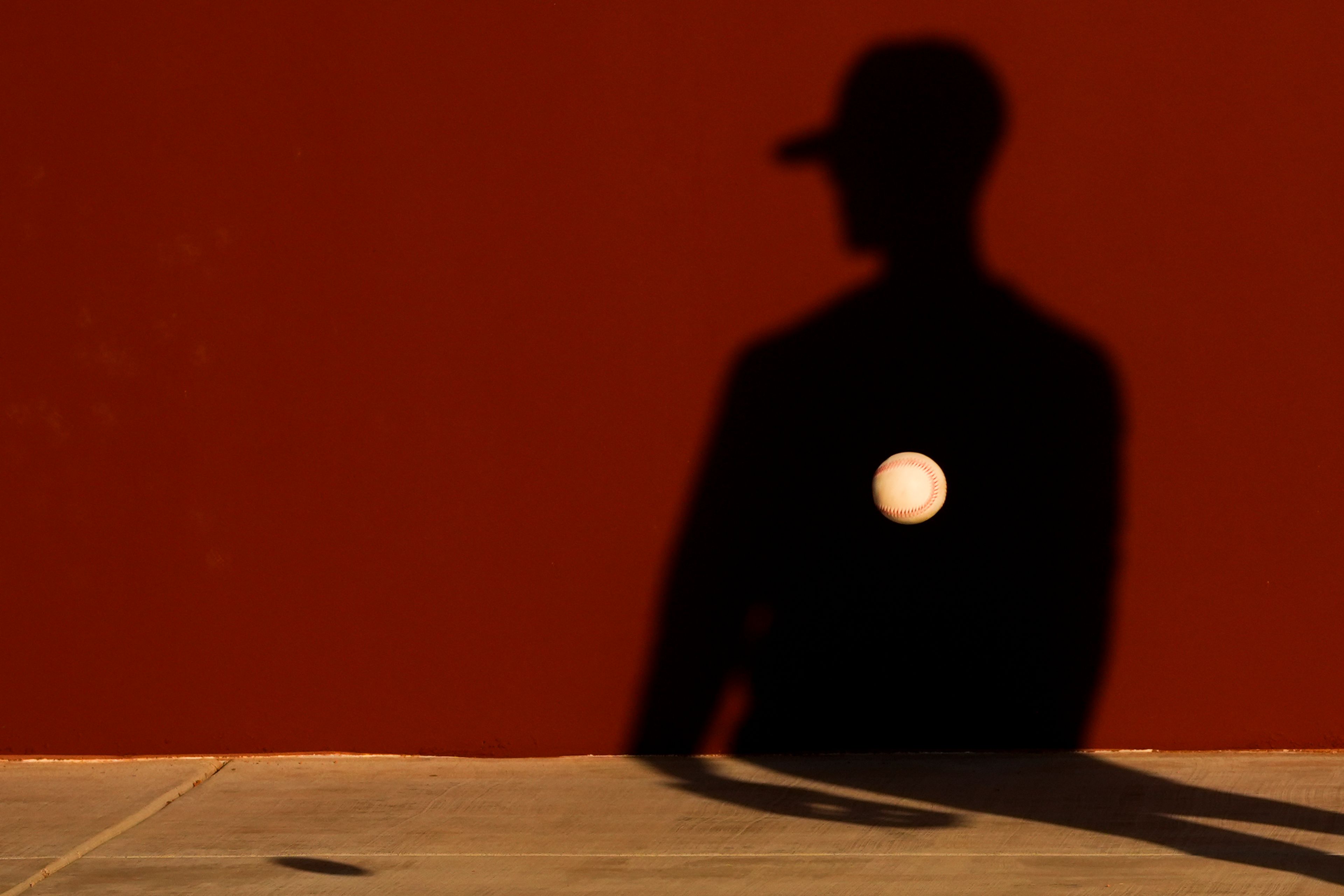 A member of the Seattle Mariners tosses a ball against a wall during drills at spring training baseball workouts, on Feb. 15, 2024, in Peoria, Ariz. (AP Photo/Lindsey Wasson)