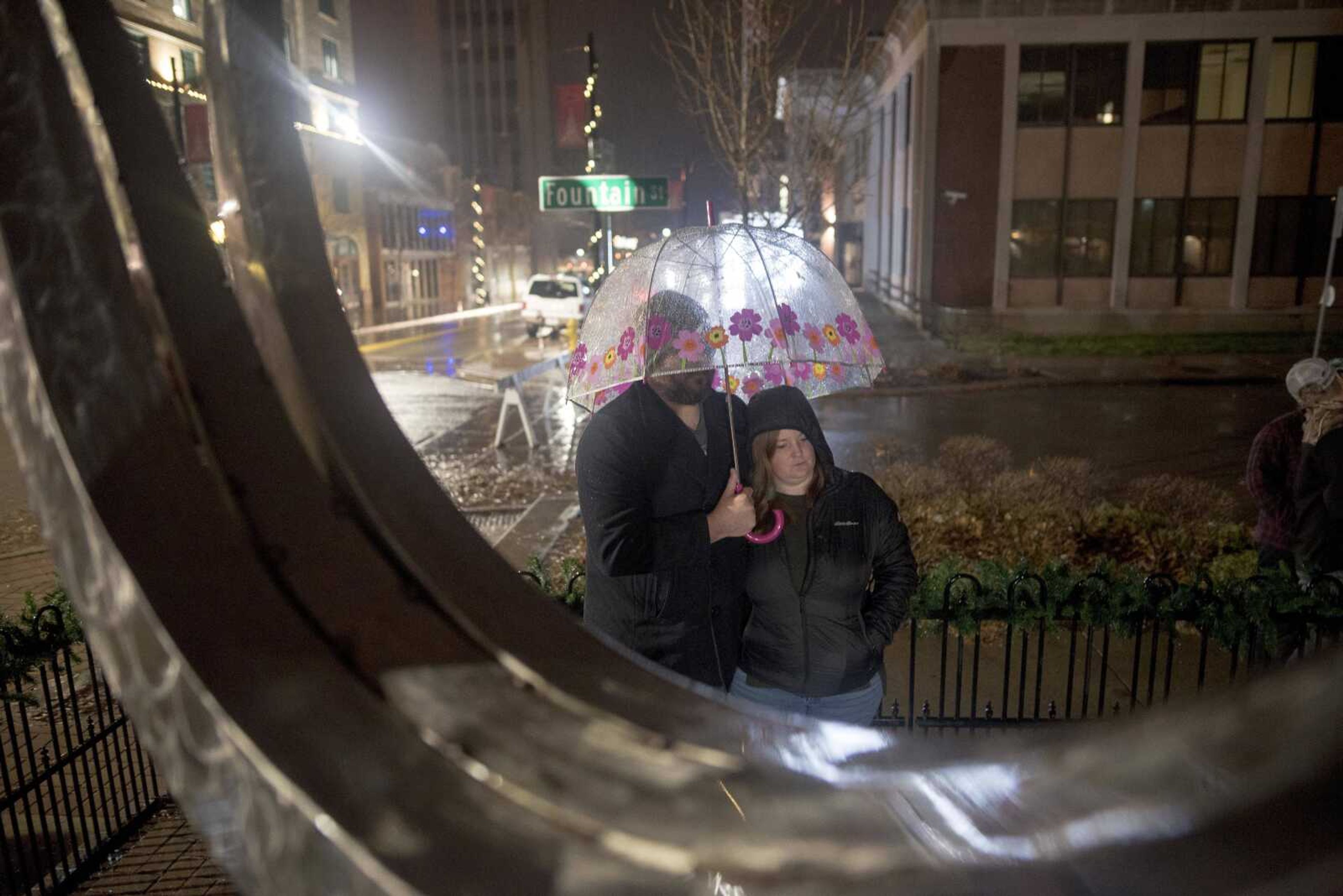 Eric Callahan and his wife, Lindsey, wait under an umbrella during the inaugural Christmas tree lighting hosted by Old Town Cape Friday, Nov. 29, 2019, at the Vasterling Suites in Cape Girardeau.