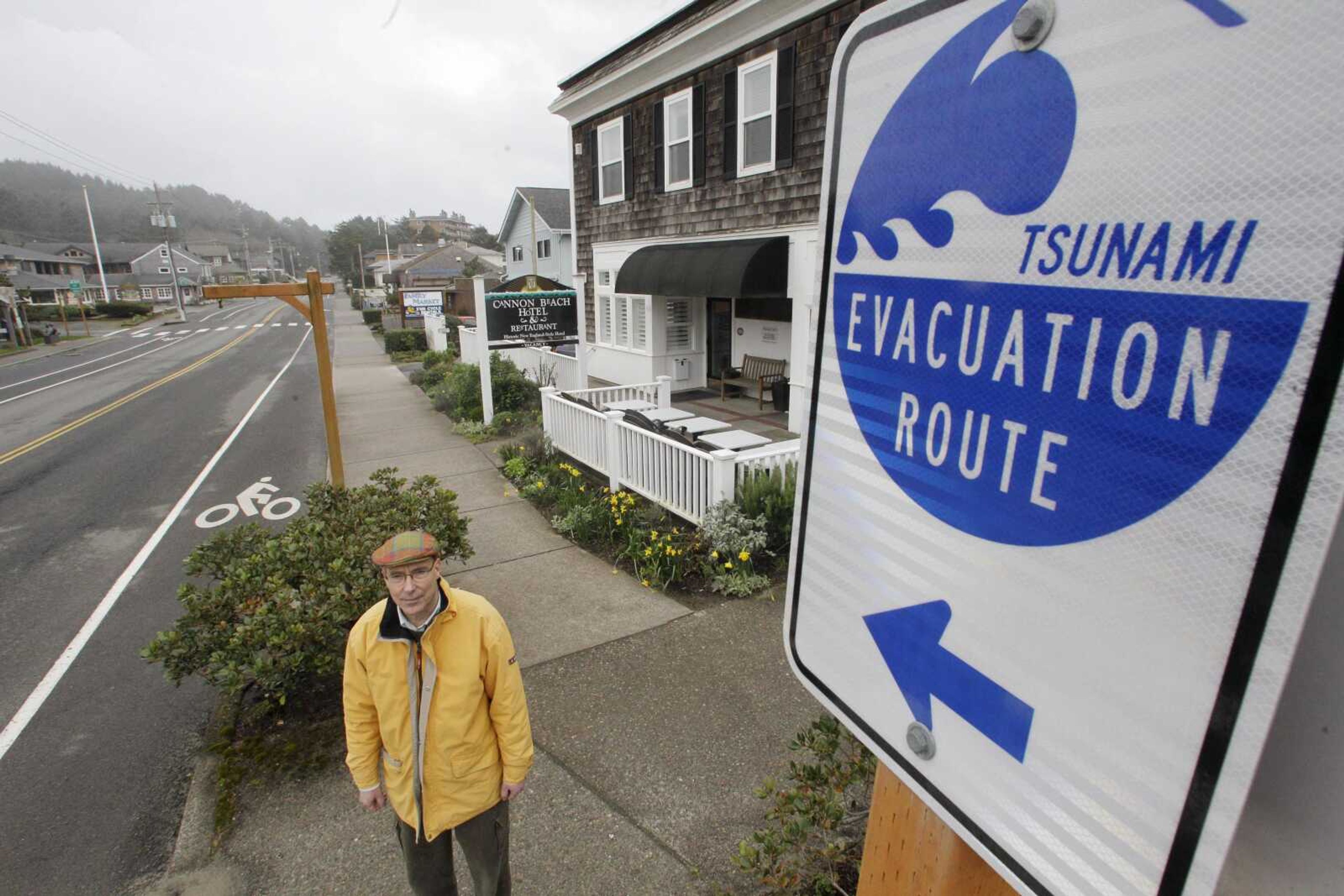 Cannon Beach, Ore., architect Jay Raskin stands in front of a tsunami evacuation sign March 16. Raskin, a former city council member and mayor has proposed replacing the current city hall, which is seismically unsound, with a two-story building on stilts. (Rick Bowmer ~ Associated Press)