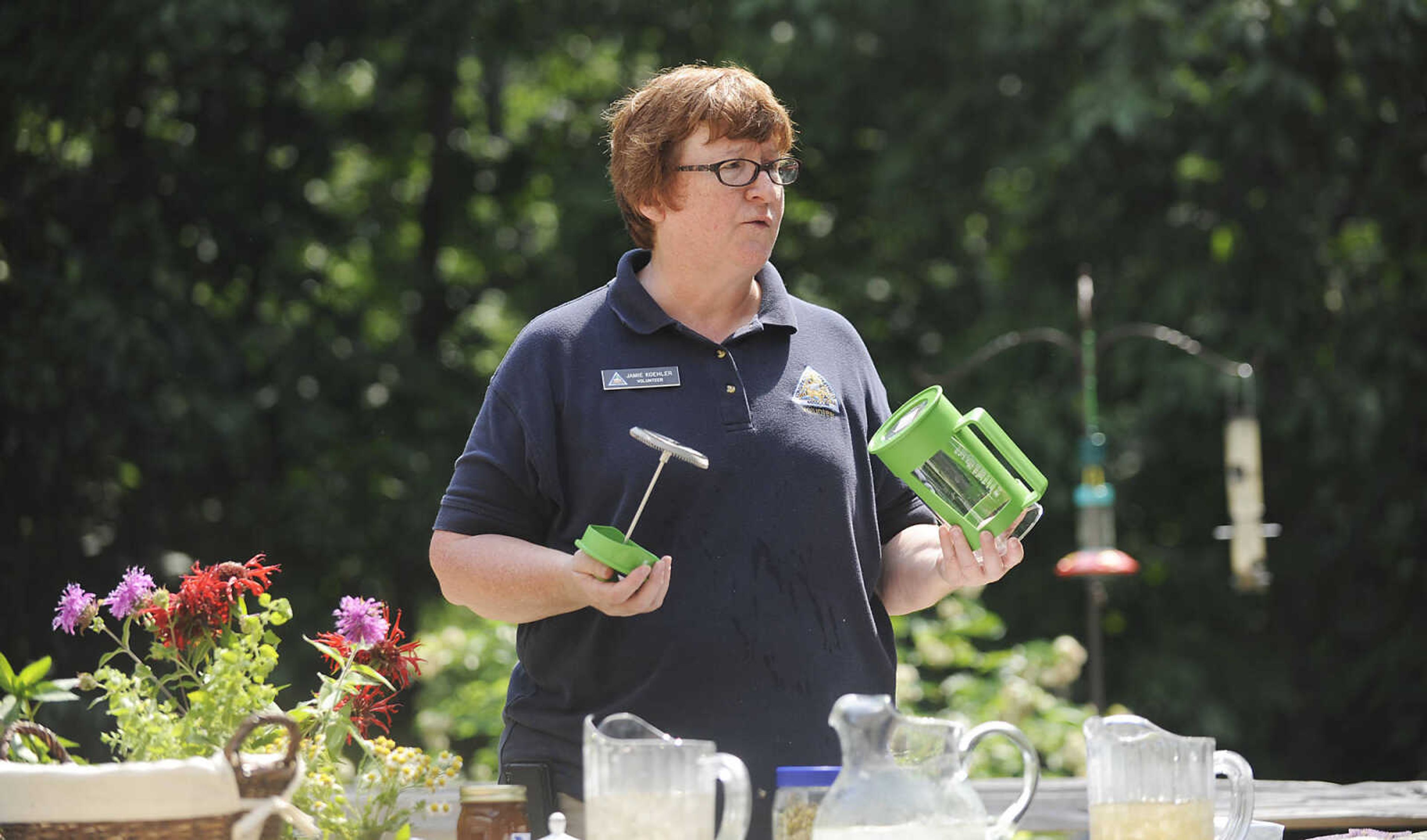 Volunteer Jamie Koehler shows a french press she uses to make tea at the Cape Girardeau Conservation Nature Center during the Garden Tea Party Saturday, June 22, at the nature center located at 2289 County Park Drive in Cape Girardeau. Koehler showed attendees several plants native to Missouri that can be used to make teas before taking them back to the center's patio for a tea party featuring food and drink made from native plants. The party was one of several educational events being held at the center this summer including the Outdoor Adventure Camp, Tuesday, June 25 to Wednesday, June 26, Dutch Oven Drop-by and Tools of the past, Saturday, June 29, Wild Edibles, Saturday, July 6, Gone Frogging, Friday, July 19, and Fishing 101 Saturday, July 27. More information on these and other events can be found on the center's website http://mdc.mo.gov/node/297