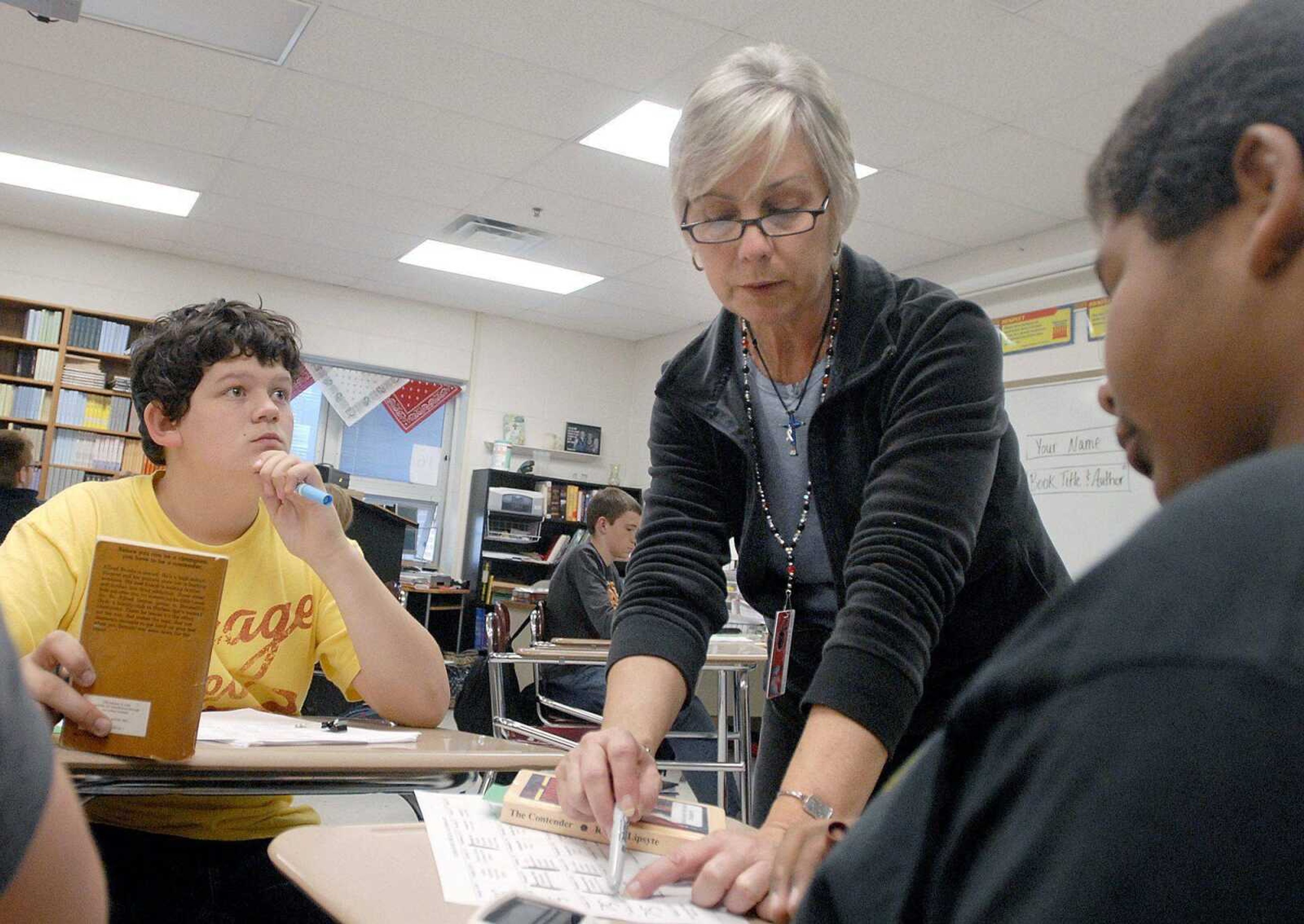 Sharlett Eftink answers questions from eighth-grade students Kevin Hunt, right, and Levi Magruder during their communication arts class Tuesday at Jackson Junior High School. (Laura Simon)