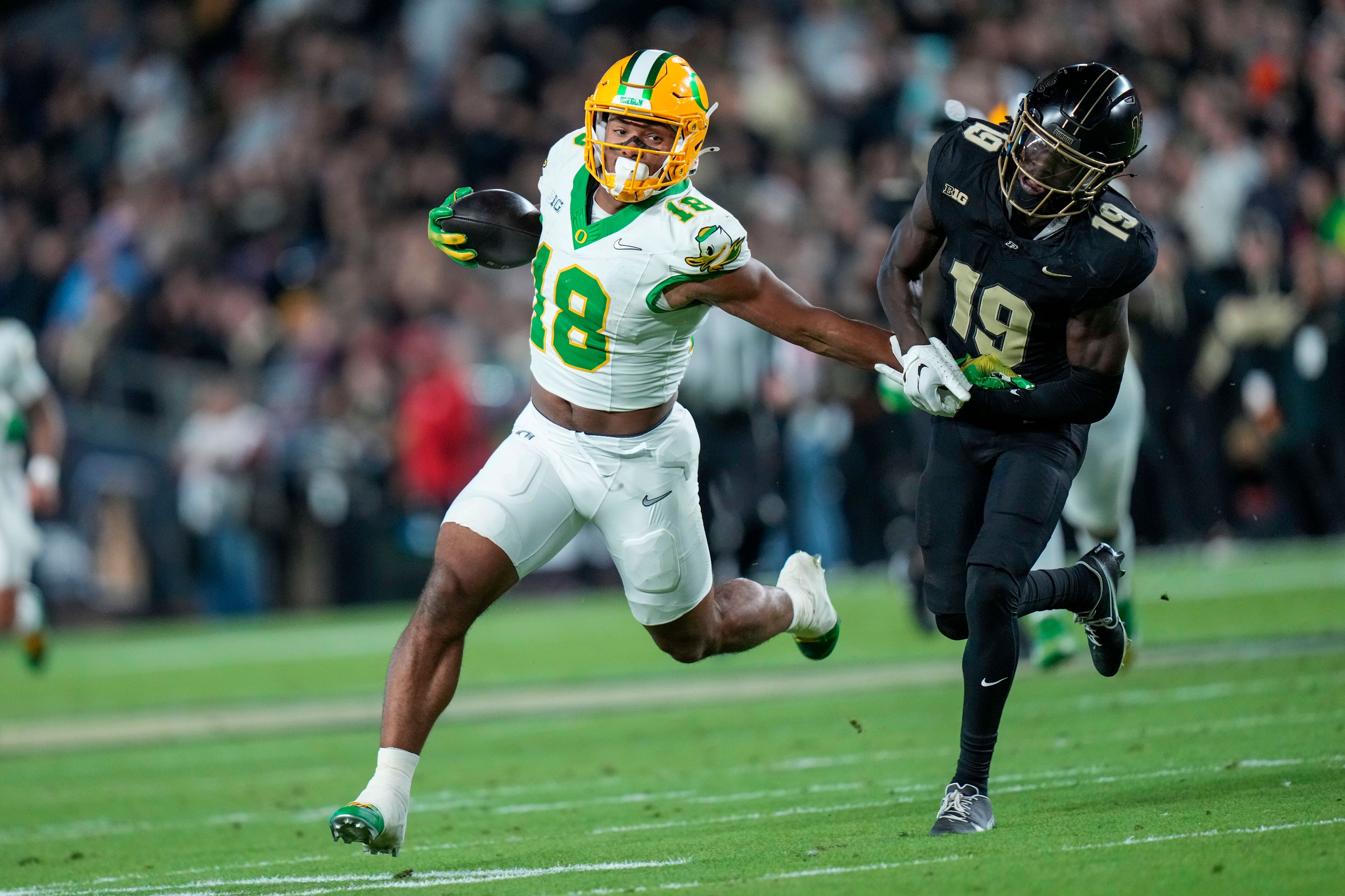 Oregon tight end Kenyon Sadiq (18) evades Purdue defensive back Botros Alisandro (19) during the first half of an NCAA college football game in West Lafayette, Ind., Friday, Oct. 18, 2024. (AP Photo/AJ Mast)