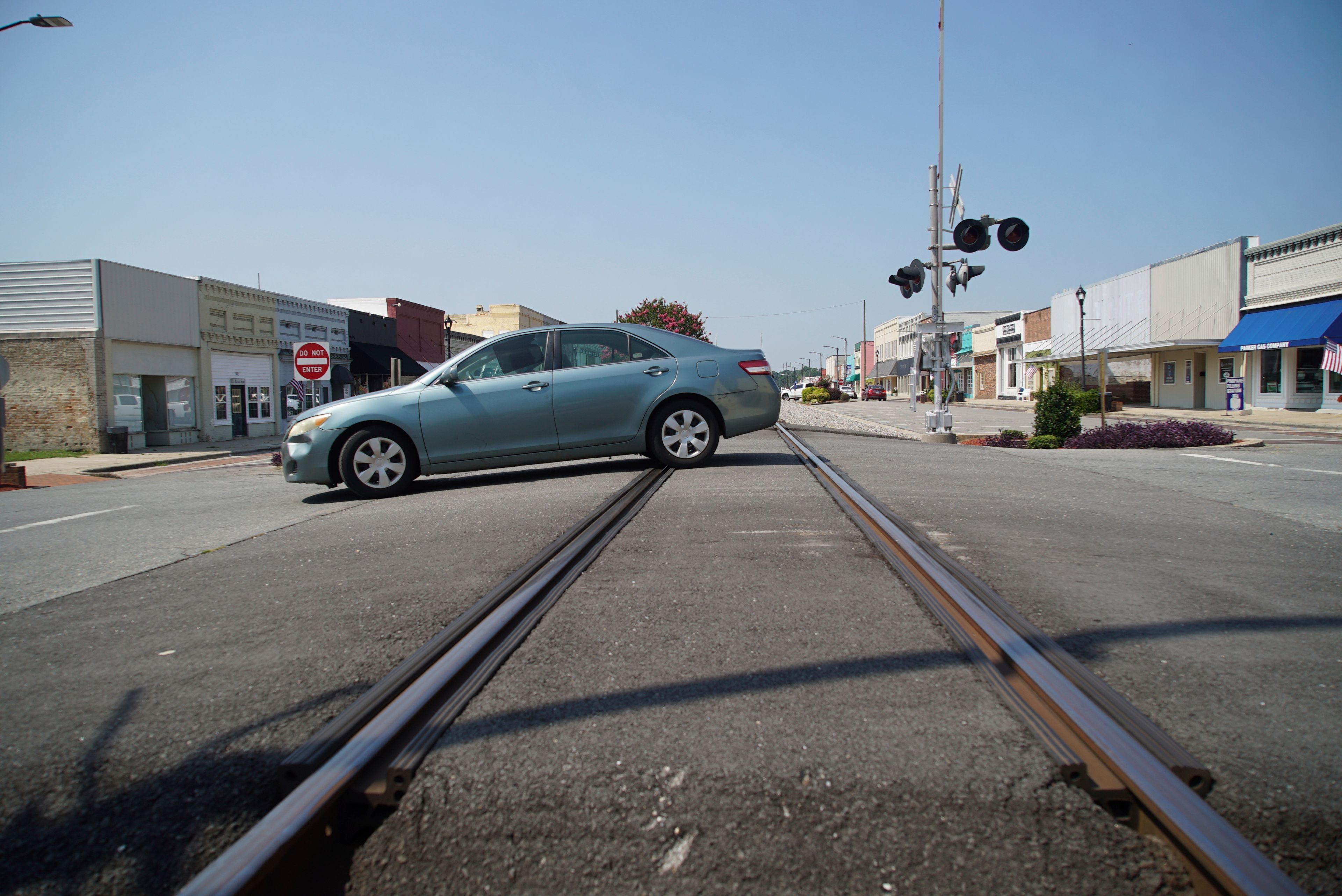 A car crosses the railroad tracks bisecting the main street in downtown Mount Olive, N.C., on Monday, July 15, 2024. (AP Photo/Allen G. Breed)