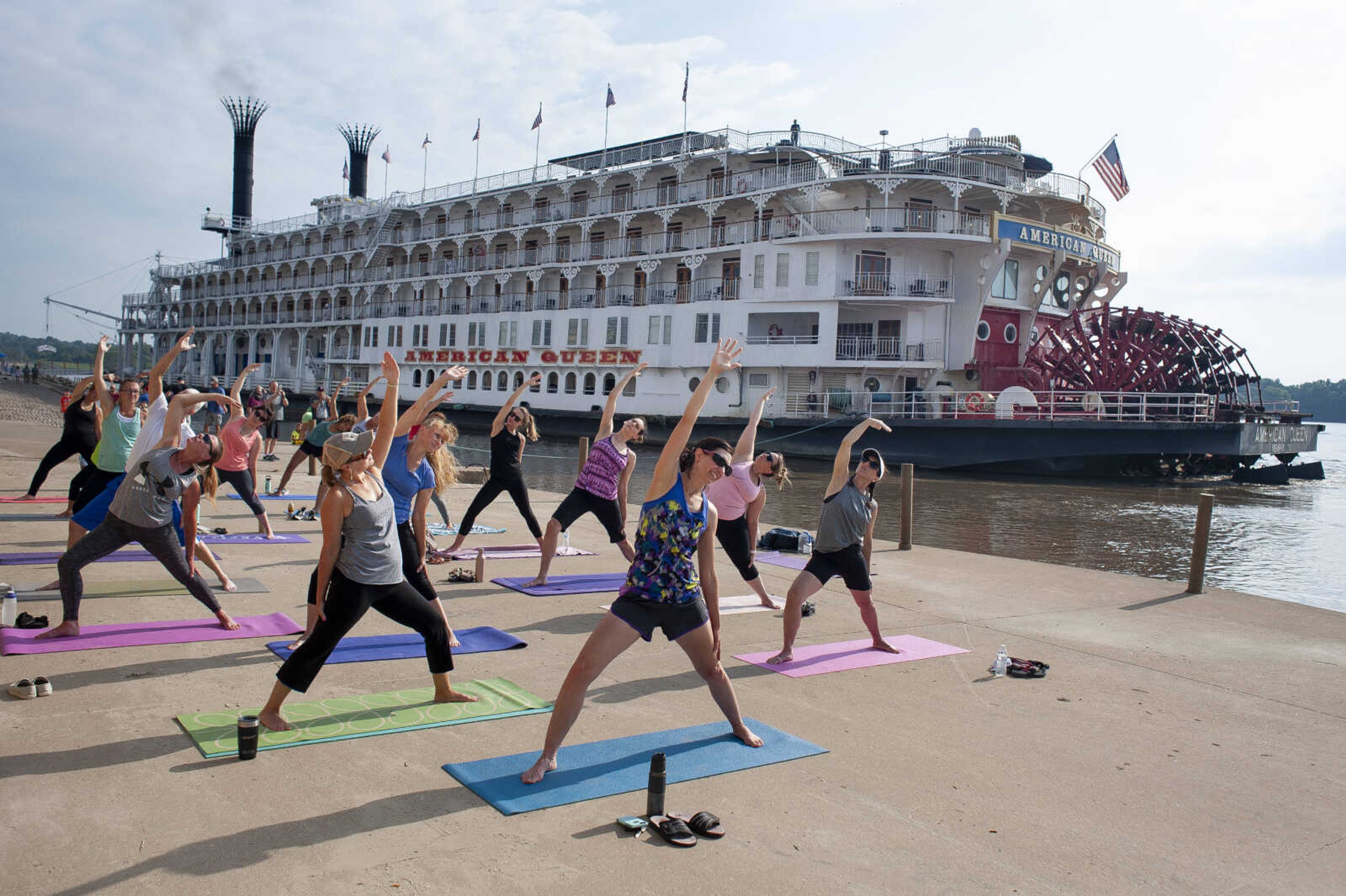 Front three classmates from left: Robin Harbison of Cape Girardeau, Colette Banda of Jackson and Cristina Welker of Jackson take part in a riverfront yoga class while the American Queen is docked Saturday, Aug. 3, 2019, along the Mississippi River in Cape Girardeau.