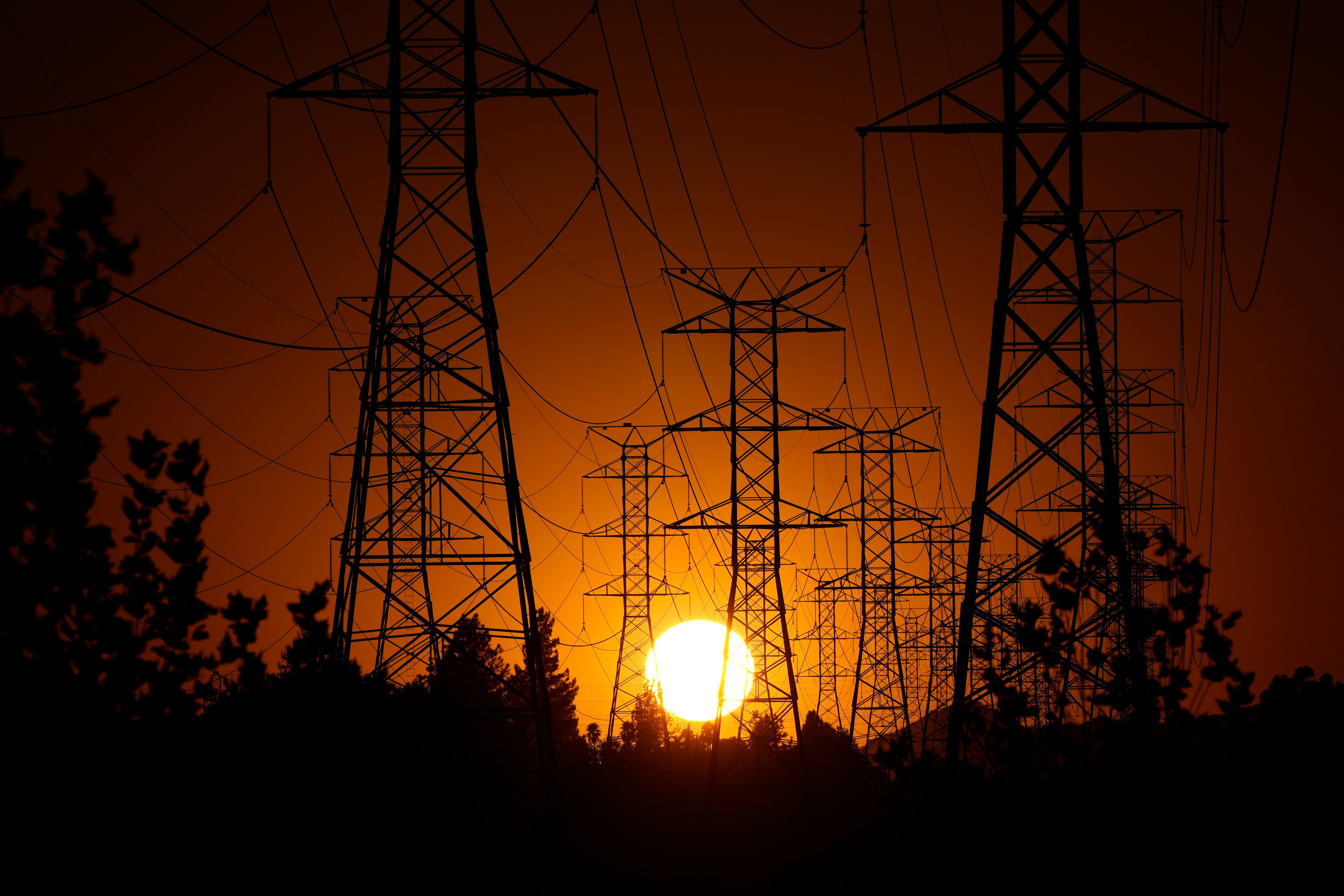 The sun sets behind high tension power lines, Monday, Sept. 23, 2024, in the Porter Ranch section of Los Angeles. (AP Photo/Mark J. Terrill)