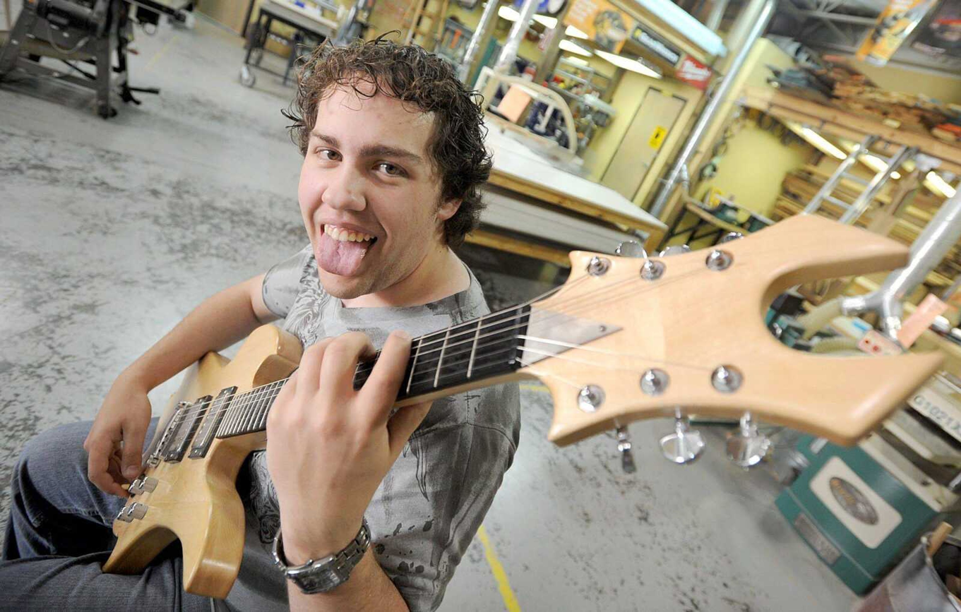 Zack Perkins strums the guitar he made his junior year in his Chaffee High School industrial arts class Tuesday. Perkins is using a spider-web design for his current guitar project. (Laura Simon)