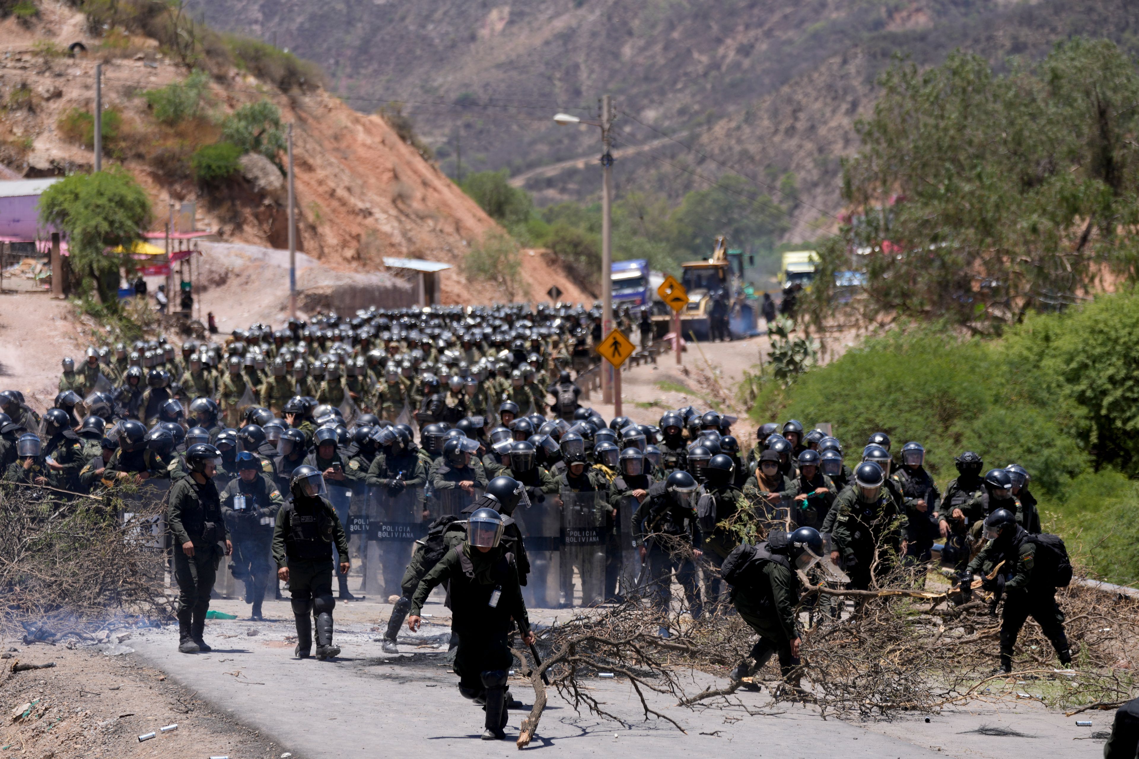 FILE - Police clear a road blocked by supporters of former President Evo Morales who have been blocking roads for weeks partly targeting President Luis Arce's handling of the economy, in Parotani, Bolivia, Nov. 1, 2024. (AP Photo/Juan Karita, File)