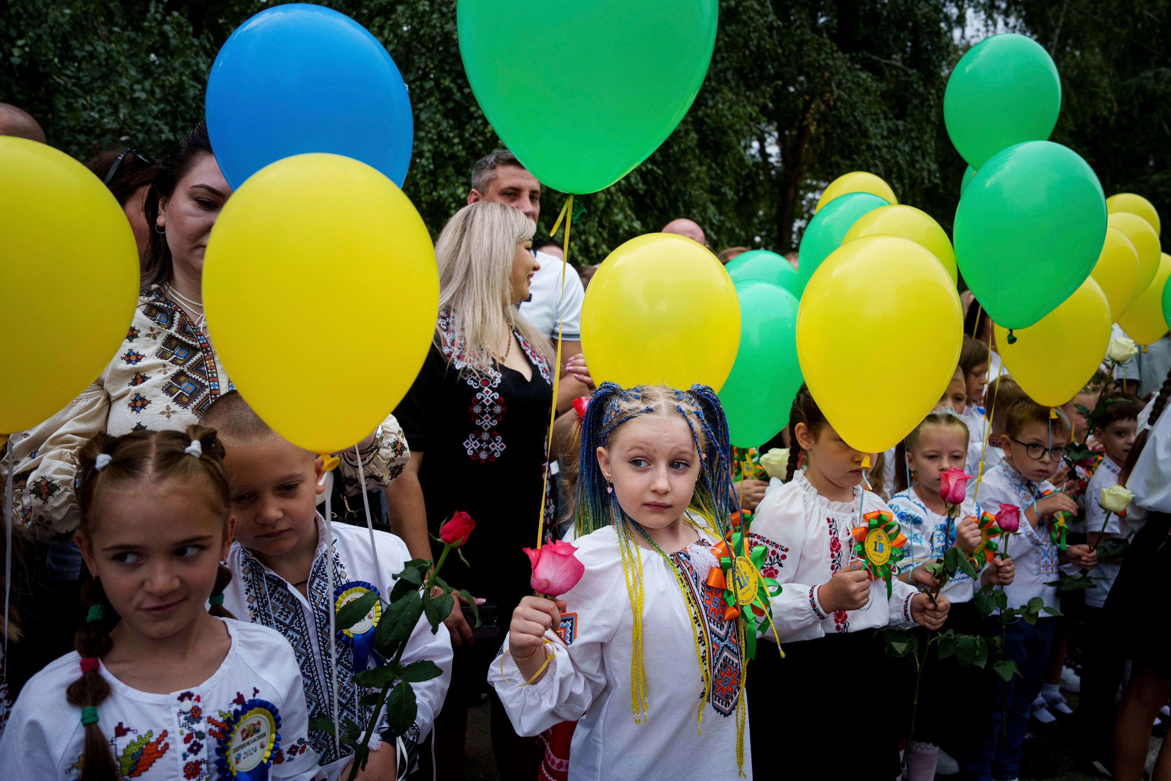 FILE - First-graders hold balloons on the first day of school in Zaporizhzhia, about 40 kilometers to the front line, Ukraine, on Sept. 1, 2024. (AP Photo/Evgeniy Maloletka, File)