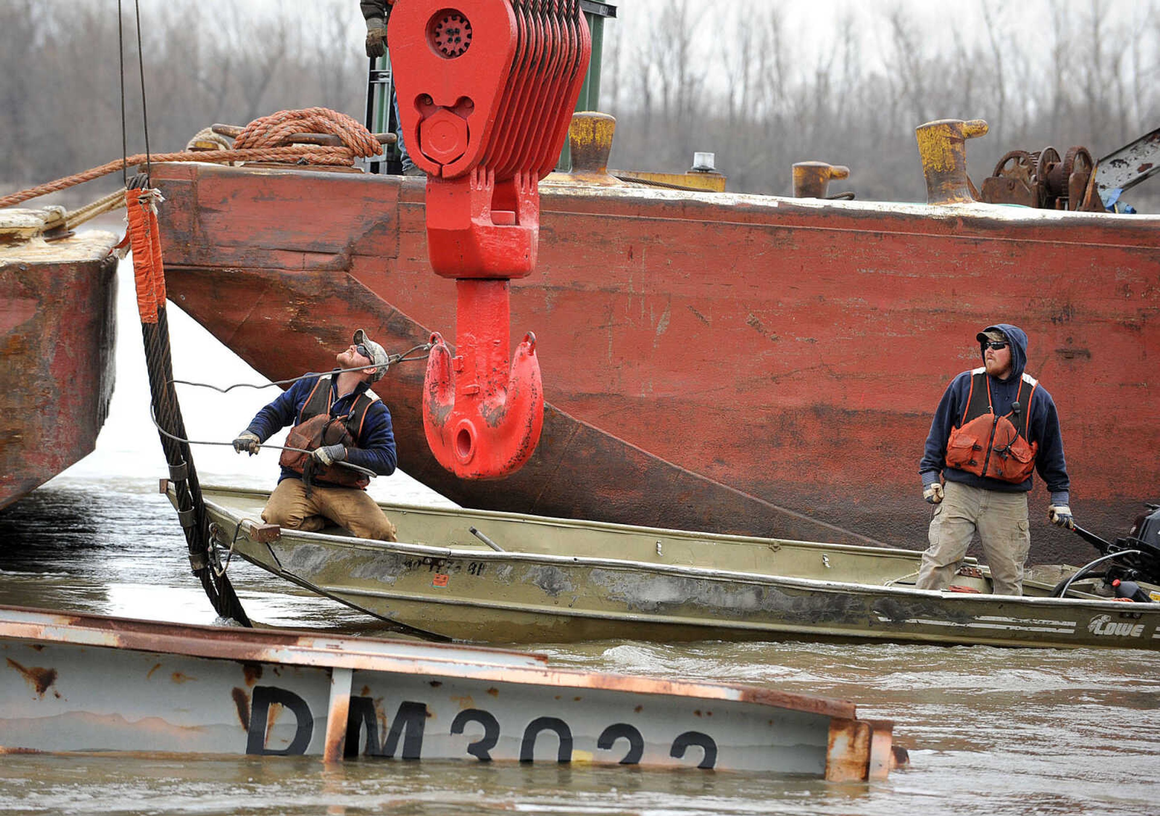 LAURA SIMON ~ lsimon@semissourian.com

Crews work to remove coal from the partially sunken barge in the Mississippi River  along the floodwall in downtown Cape Girardeau, Tuesday, April 2, 2013. The barge is one of 13 that broke loose from the Sheila Johnson on March 24 after it struck something in the river near mile marker 60 north of Cape Girardeau. A floating crane has a harness around the sunken portion while crews on a separate barge remove the coal.