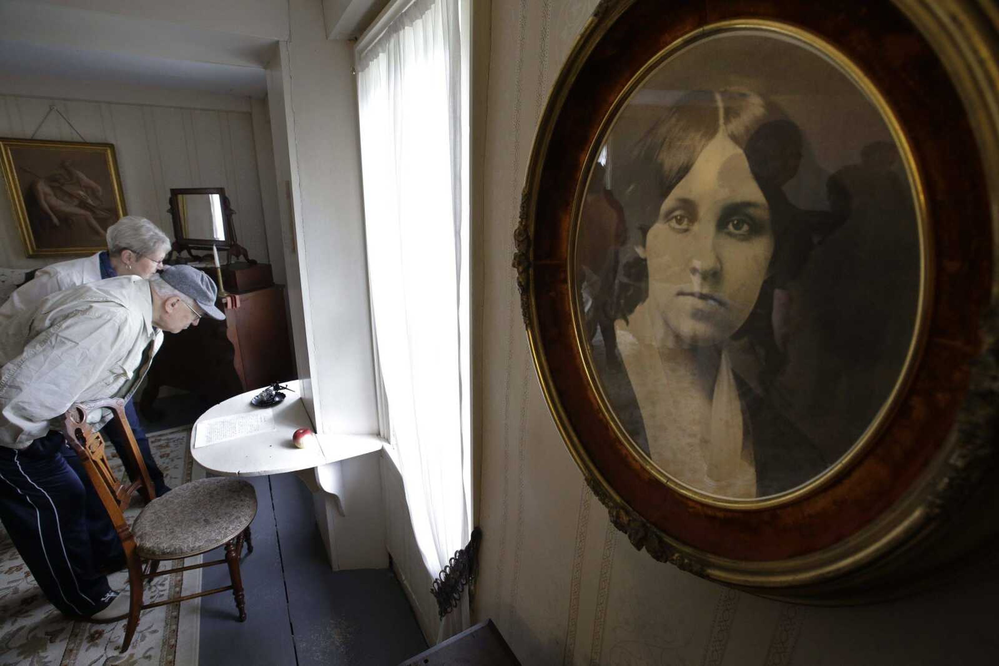 Samuel Ruggiero of Erie, Pennsylvania, front left, examines the desk where author Louisa May Alcott sat while writing the book "Little Women" at Orchard House in Concord, Massachusetts.