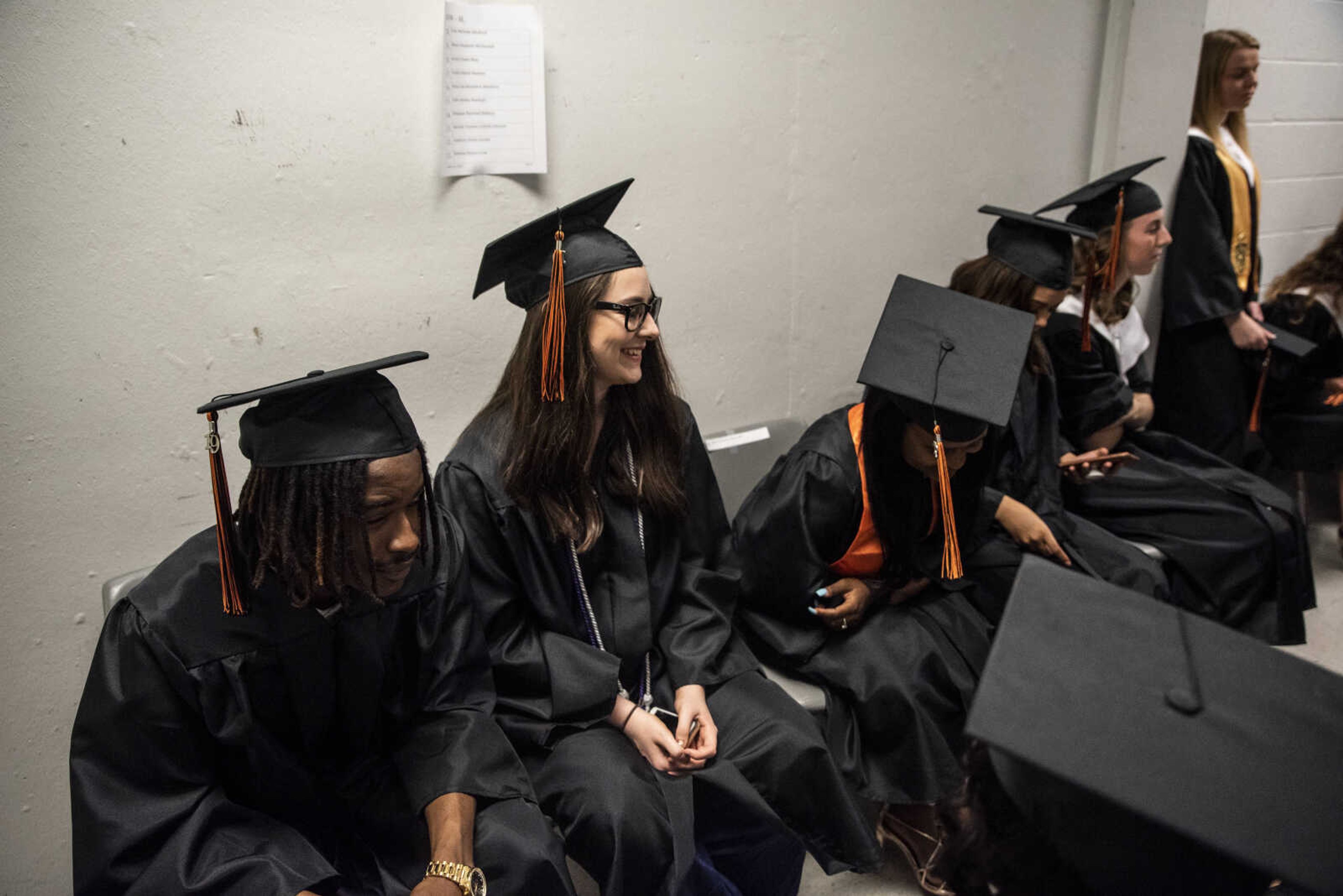 Emily Medlock, center, laughs with classmates while waiting for graduation to start at the Show Me Center Sunday, May 12, 2019, in Cape Girardeau.