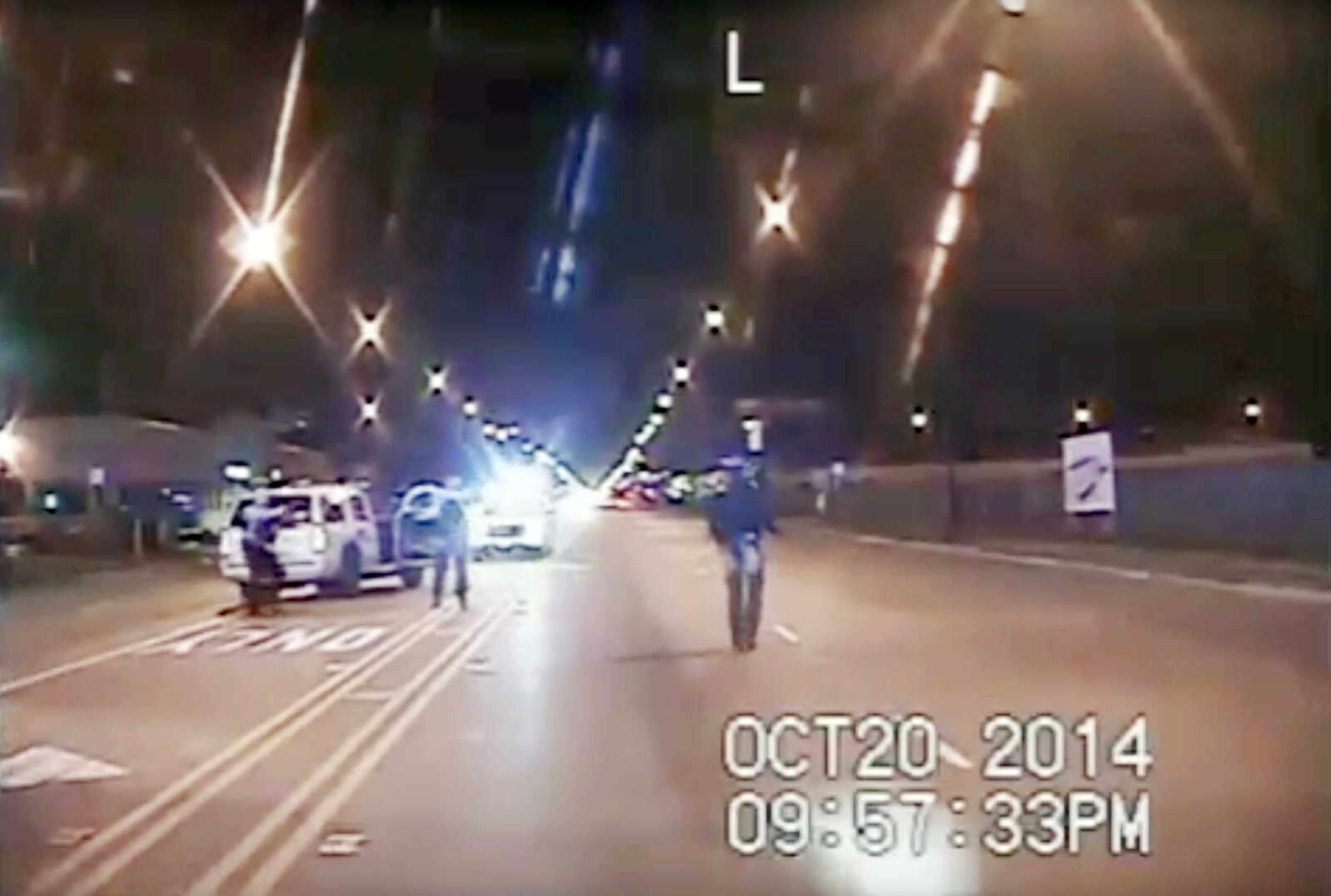 In this Oct. 20, 2014, frame from dash-cam video, Laquan McDonald, right, walks down the street moments before being shot by officer Jason Van Dyke in Chicago. (Chicago Police Department via AP, file)