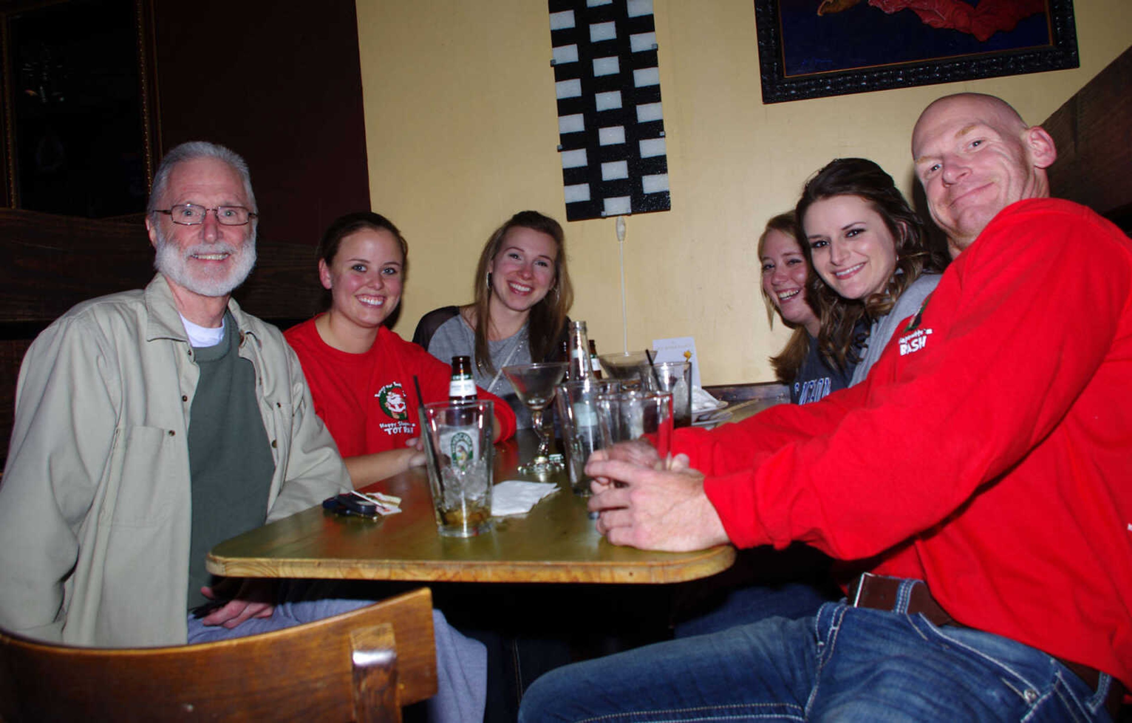 Steve Mosley, left, Suzanne Carter, Lindsey Wehmeyer, Jordan Seabaugh, Laura Bos and Chris Eastridge enjoy drinks together in downtown Cape Girardeau during the 10th annual Happy Slapowitz's Toy Bash on Thursday Dec. 13, 2012.