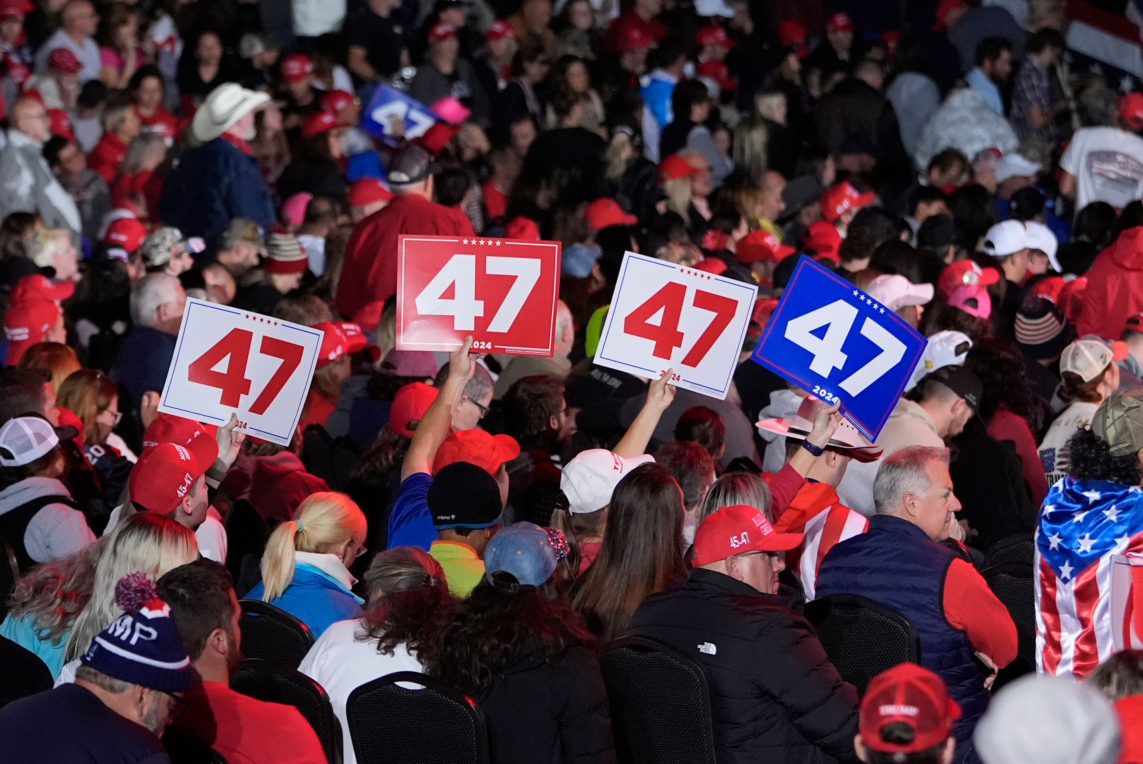 Supporters hold signs at a campaign rally for Republican presidential nominee former President Donald Trump at the Suburban Collection Showplace, Saturday, Oct. 26, 2024 in Novi, Mich. (AP Photo/Carlos Osorio)