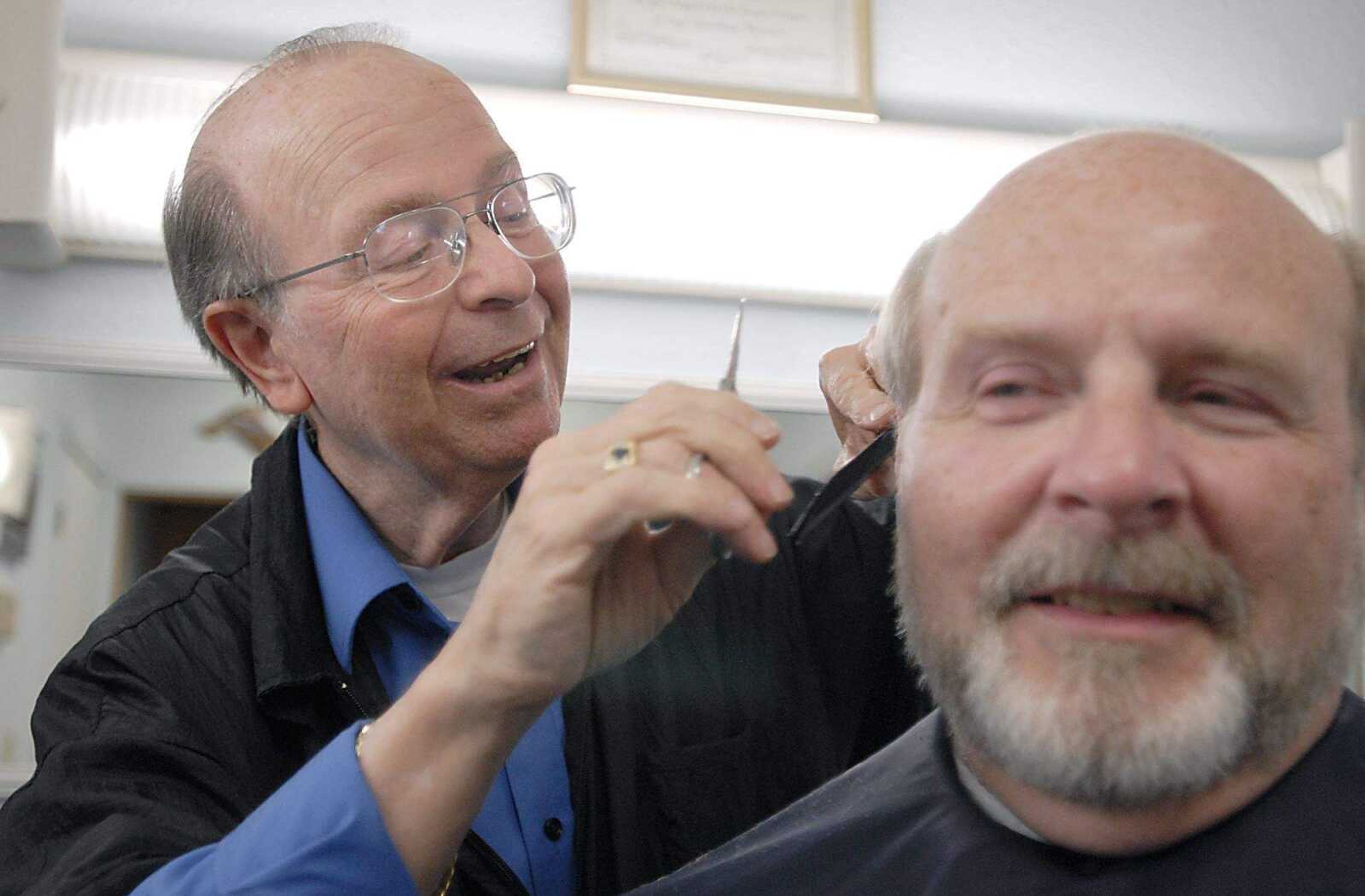 KIT DOYLE ~ kdoyle@semissourian.com
Barber Bill Sisco joked with Frank Batchelor Friday afternoon, June 13, 2008, at Sisco's Barber and Hairstyling near the intersection of Sprigg and Broadway in Cape Girardeau. Batchelor was one of Sisco's first customers 48 years ago when Sisco was then referred to as "Junior" and had the back room as his father Bill Sisco Senior had the front room. "I wouldn't take a spot in the mall if they gave it to me," Sisco said. "This is the pace to be."