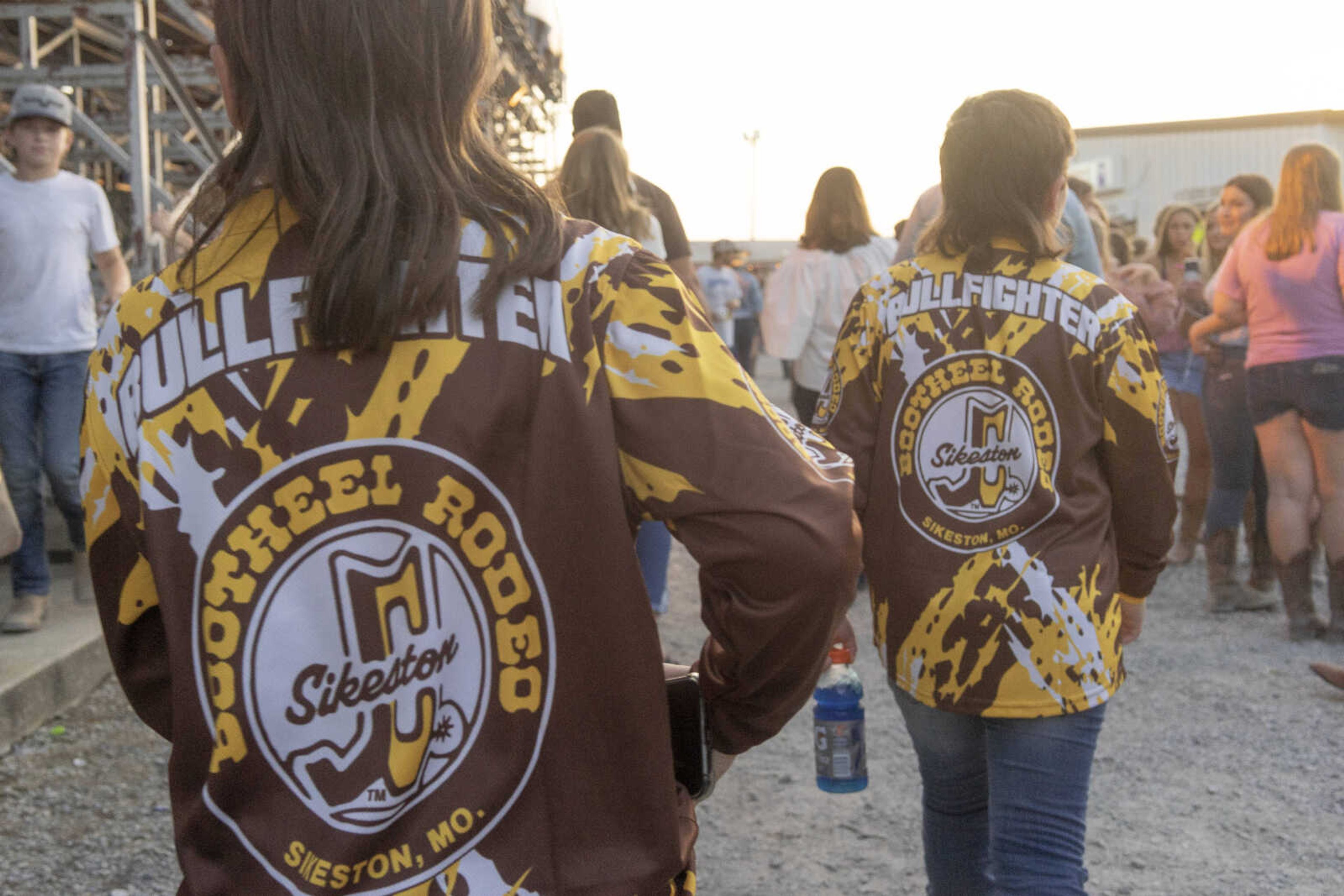 Brothers Peyton, right, and Chord Lehman make their way through the crowd in matching jerseys - inspired by their own love of bull riding and saddle broncing -  during the first night of the Sikeston Jaycee Bootheel Rodeo on Wednesday, Aug. 11, 2021, in Sikeston, Missouri.