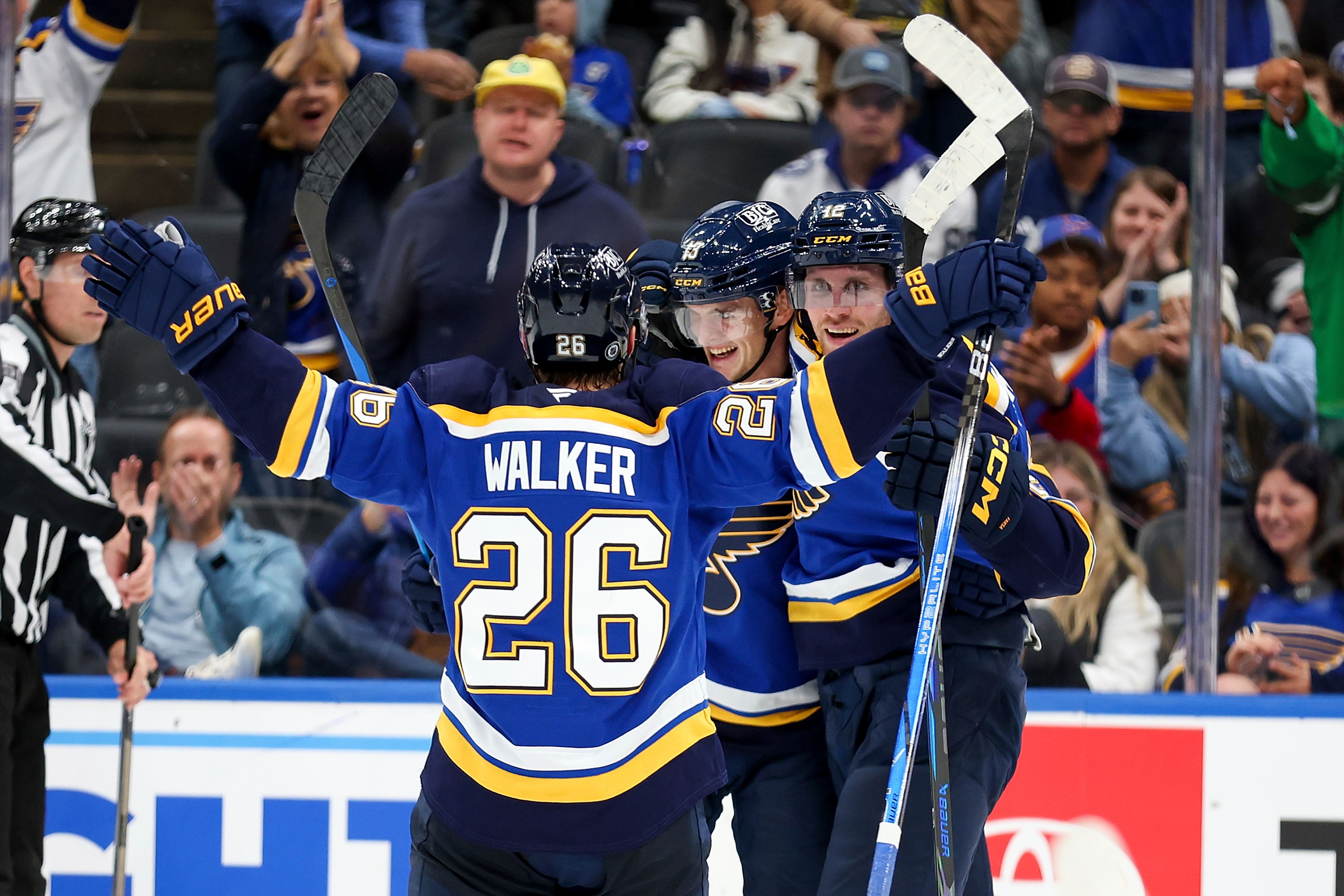 St. Louis Blues' Alexey Toropchenko (13) is congratulated by teammates Nathan Walker (26) and Radek Faksa (12) after scoring a goal during the second period of an NHL hockey game against the Tampa Bay Lightning Tuesday, Nov. 5, 2024, in St. Louis. (AP Photo/Scott Kane)