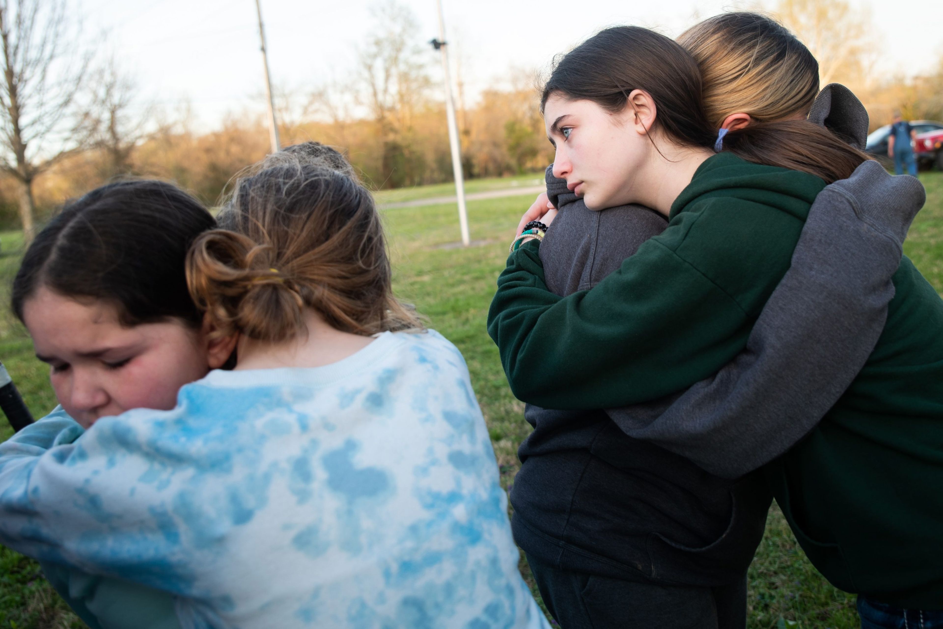 From left, Emma Shipley, 9, Brooklyn Sitze, 11, Alivia Rohan, 14, and Alyssa Sitze, 12, hug one another as they mourn the loss of family members at a prayer vigil Wednesday, April 5, at Magnolia Park in Marble Hill, Missouri. The photos from this story and photo gallery won third place in best photo package in the Missouri Press's Better Newspaper Contest.