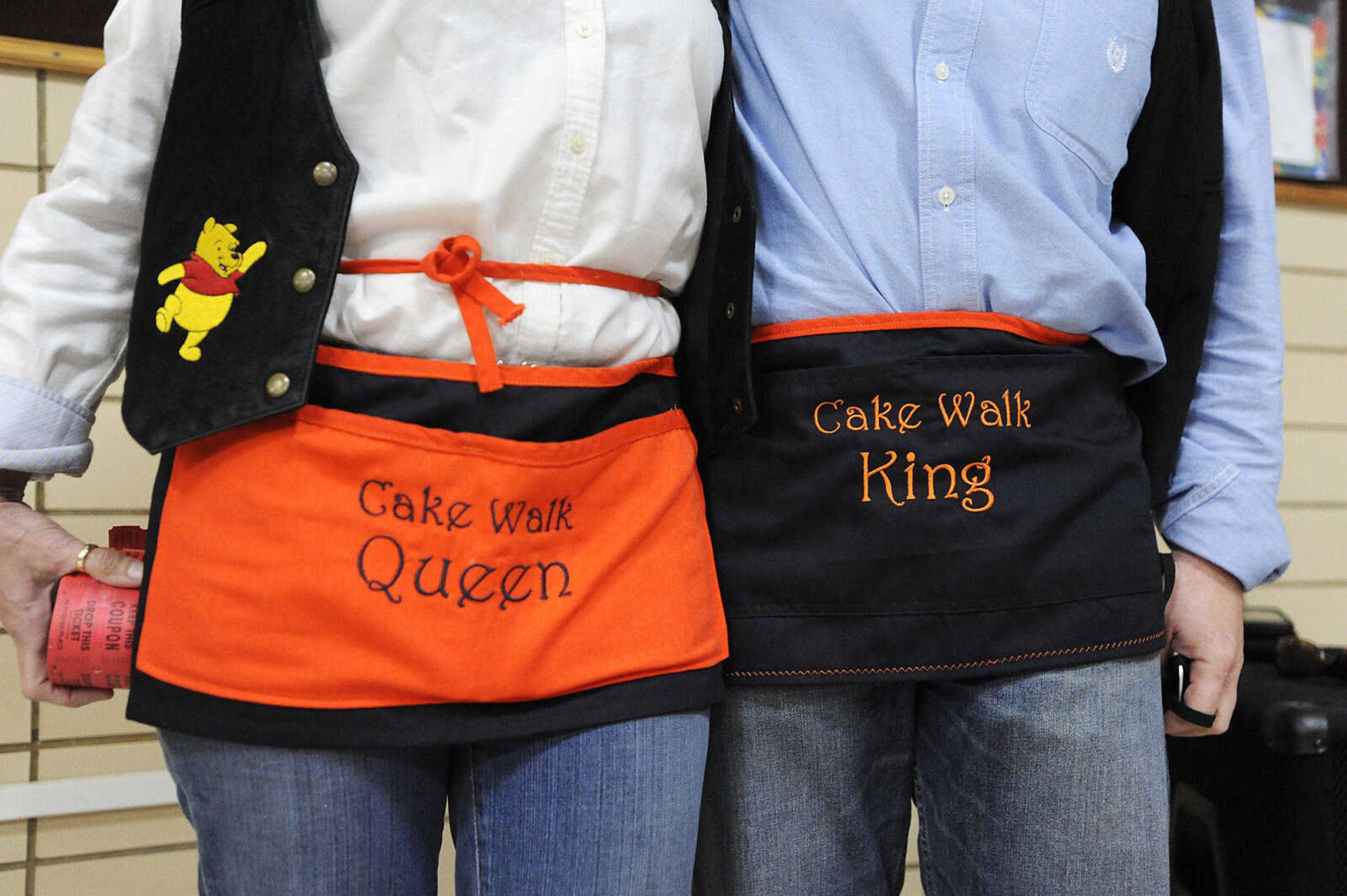 Lana and Mark Cook show off their matching aprons, which read 'Cake Walk Queen,' and 'Cake Walk King,' at the Jefferson Elementary Chili Dinner Friday night. Mark Cook is retiring from his position as principal of the school.