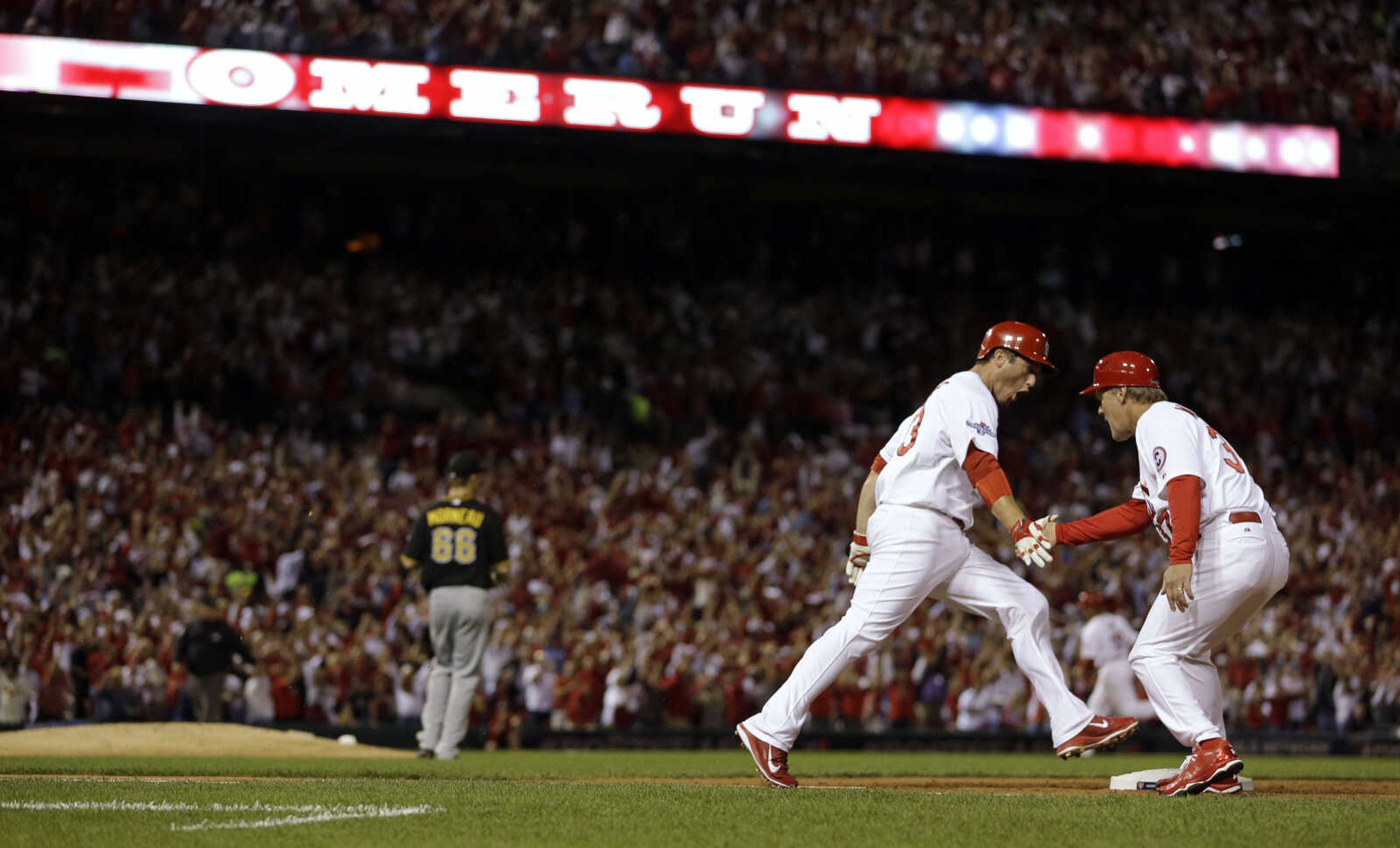 St. Louis Cardinals' David Freese is congratulated by first-base coach Chris Maloney, right, after Freese hit a two-run home run against the Pittsburgh Pirates in the second inning of Game 5 of a National League baseball division series, Wednesday, Oct. 9, 2013, in St. Louis. (AP Photo/Jeff Roberson)