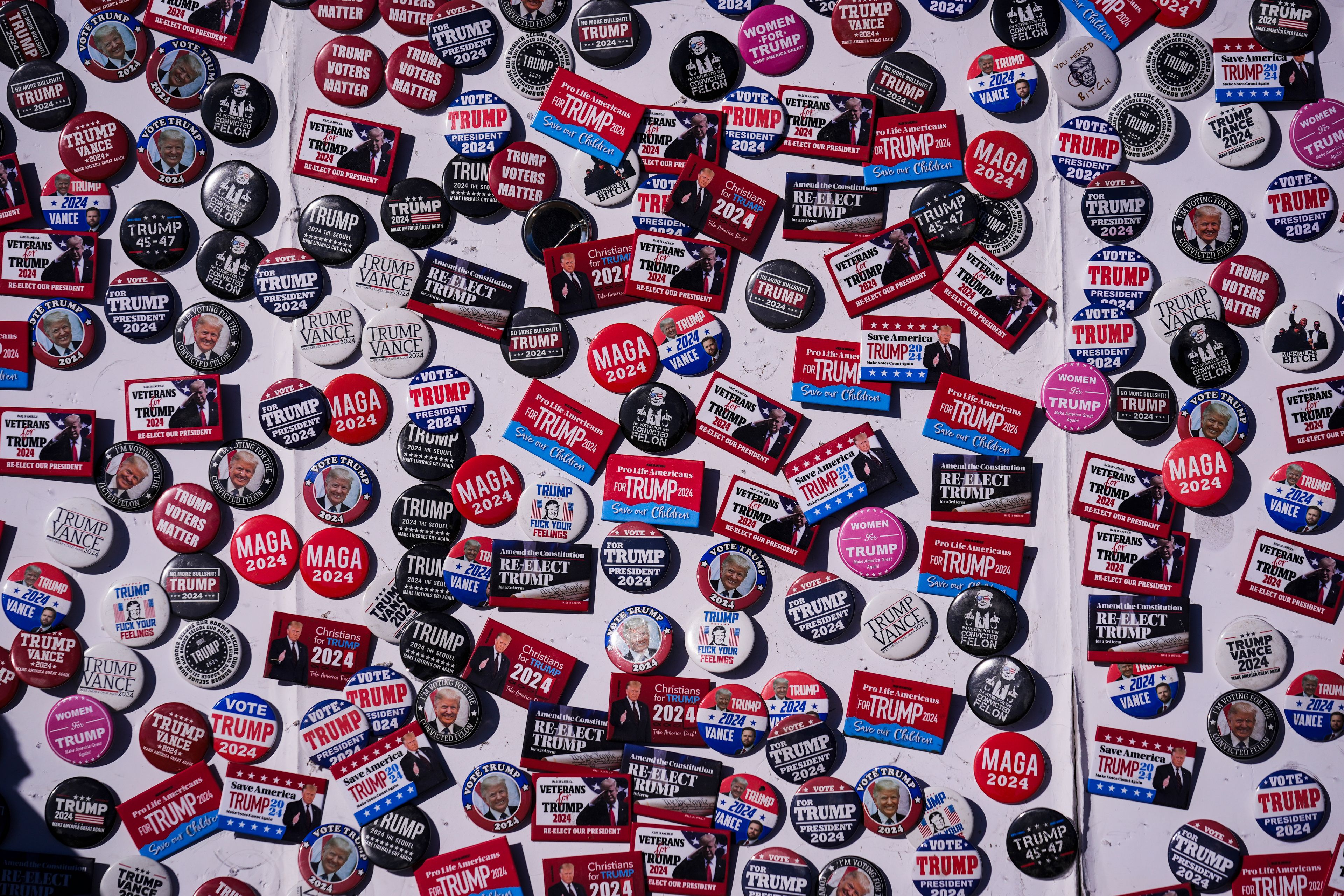 Vendors buttons for sale are pictured ahead of a Republican presidential nominee former President Donald Trump campaign rally, Saturday, Oct. 19, 2024, at Arnold Palmer Regional Airport in Latrobe, Pa. (AP Photo/Matt Rourke)