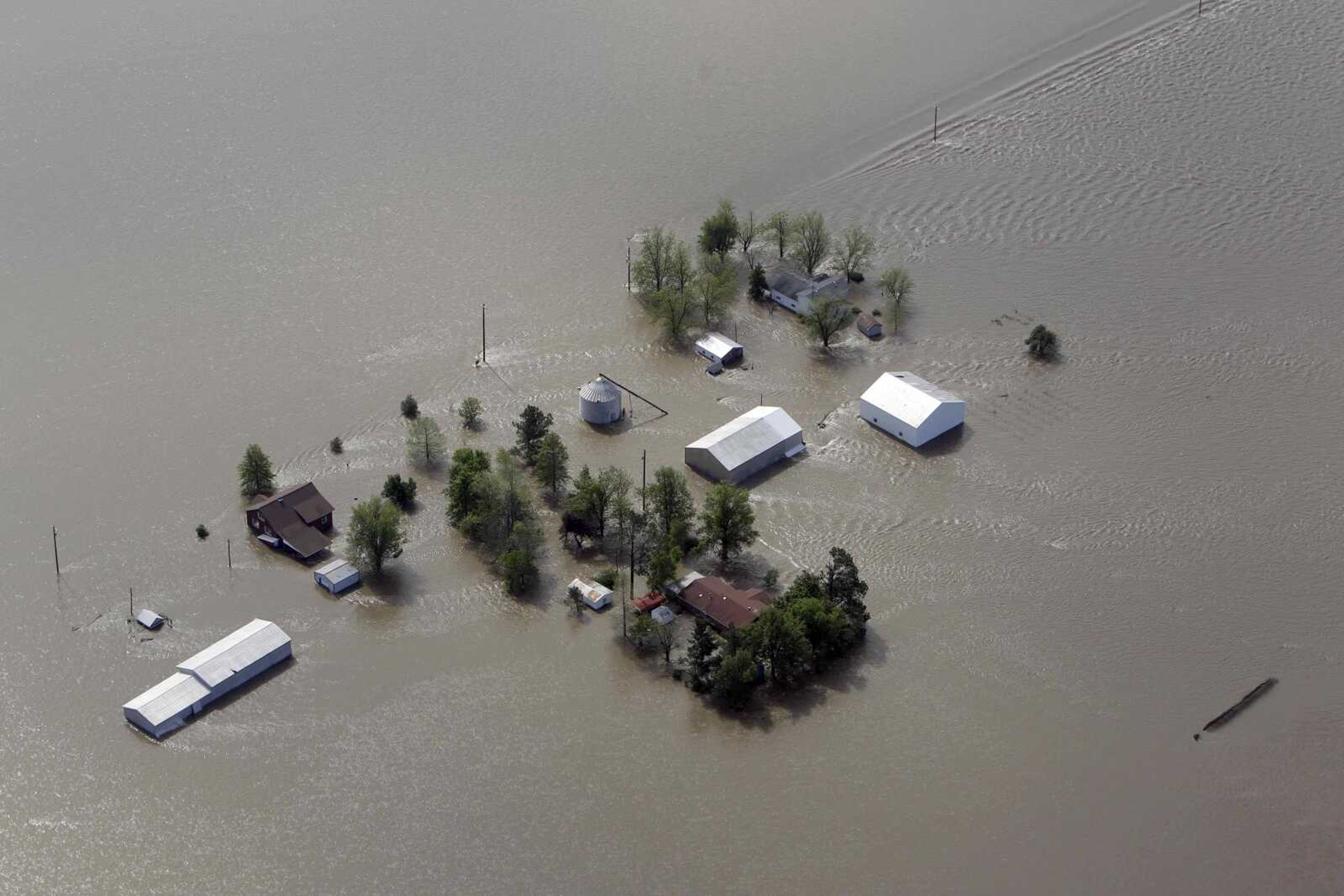 In this May 3, 2011, file photo a farm is surrounded by floodwater after the Army Corps of Engineers' blew a two-mile hole into the Birds Point levee in Southeast Missouri.  (AP Photo/Jeff Roberson, File)