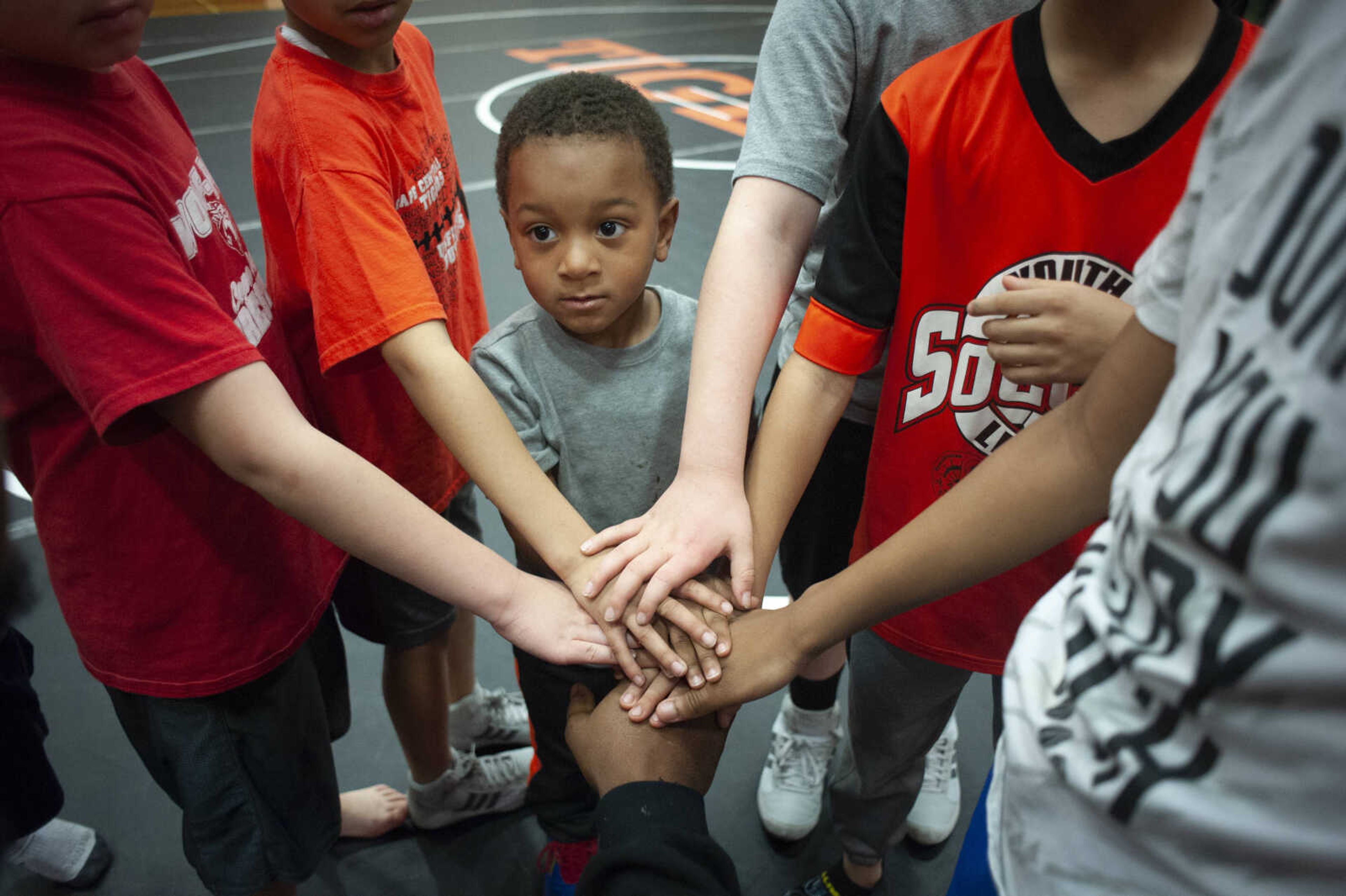 Ronald "Tripp" Coleman III of Cape Girardeau, 3, puts his hand in with others in the Wolfpack team during a match Tuesday, March 19, 2019, at Cape Central High School.